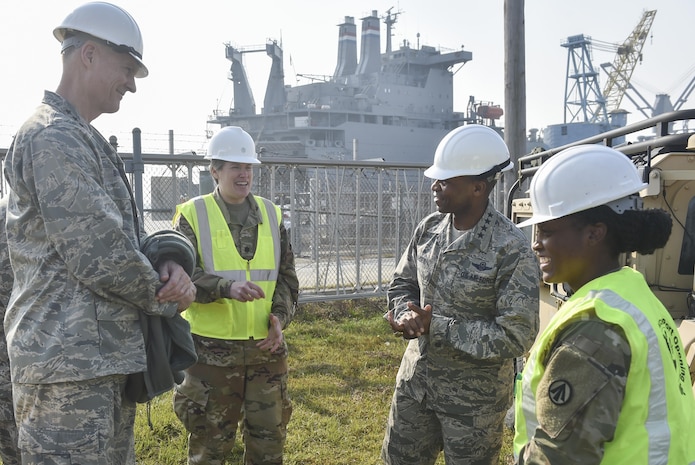 U.S. Air Force Gen. Darren W. McDew, U.S. Transportation Command (TRANSCOM) commander, center right, receives a briefing from U.S. Army 1st Lt. Laquinta Johnson, 833rd Transportation Battalion (Trans. Bn.) clearance platoon leader, right, along with U.S. Air Force Lt. Gen. Andrew E. Busch, Defense Logistics Agency director, left, and U. S. Army Lt. Col.  Stacy M. Tomic, 833rd Trans. Bn. commander, Nov.16, 2016, at Joint Base Charleston - Weapons Station, South Carolina. Johnson briefed the group on procedures for scanning equipment as it is loaded on and off of a ship. The tour showcased a Joint Task Force Port Opening for a seaport of debarkation to attendees of the U.S. TRANSCOM Component Commanders conference.