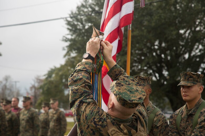 U.S. Marine Corps Brig. Gen. Thomas Weidley, commanding general, Marine Corps Installations East, Marine Corps Base Camp Lejeune (MCIEAST, MCB CAMLEJ) attaches a Meritorious Unit Commendation streamer to the colors during ceremony on Camp Lejeune, Nov. 14, 2016. Headquarters and Support Battalion, MCIEAST, MCB CAMLEJ conducted a 7.5 mile motivational and educational hike in recognition of the 75th anniversary of Camp Lejeune.