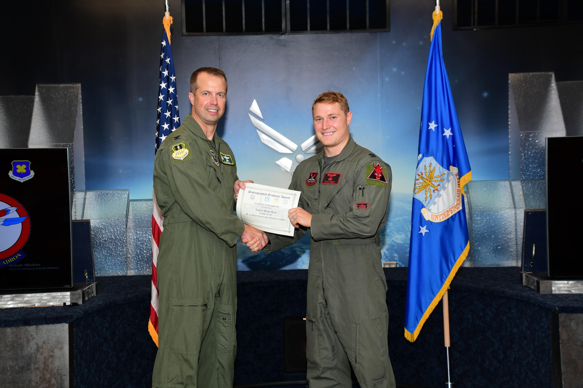 U.S. Air Force Col. Ty Neuman, commander of the 2nd  Bomb Wing, presents the Pilot Distinguished Graduate Award to Capt. Shaun Bean during a Formal Training Unit (FTU) graduation ceremony, November 18, 2016, Barksdale Air Force Base, La. Bean graduated from the FTU as a pilot on the B-52H Stratofortress. (U.S. Air Force photo by Master Sgt. Laura Siebert /Released)