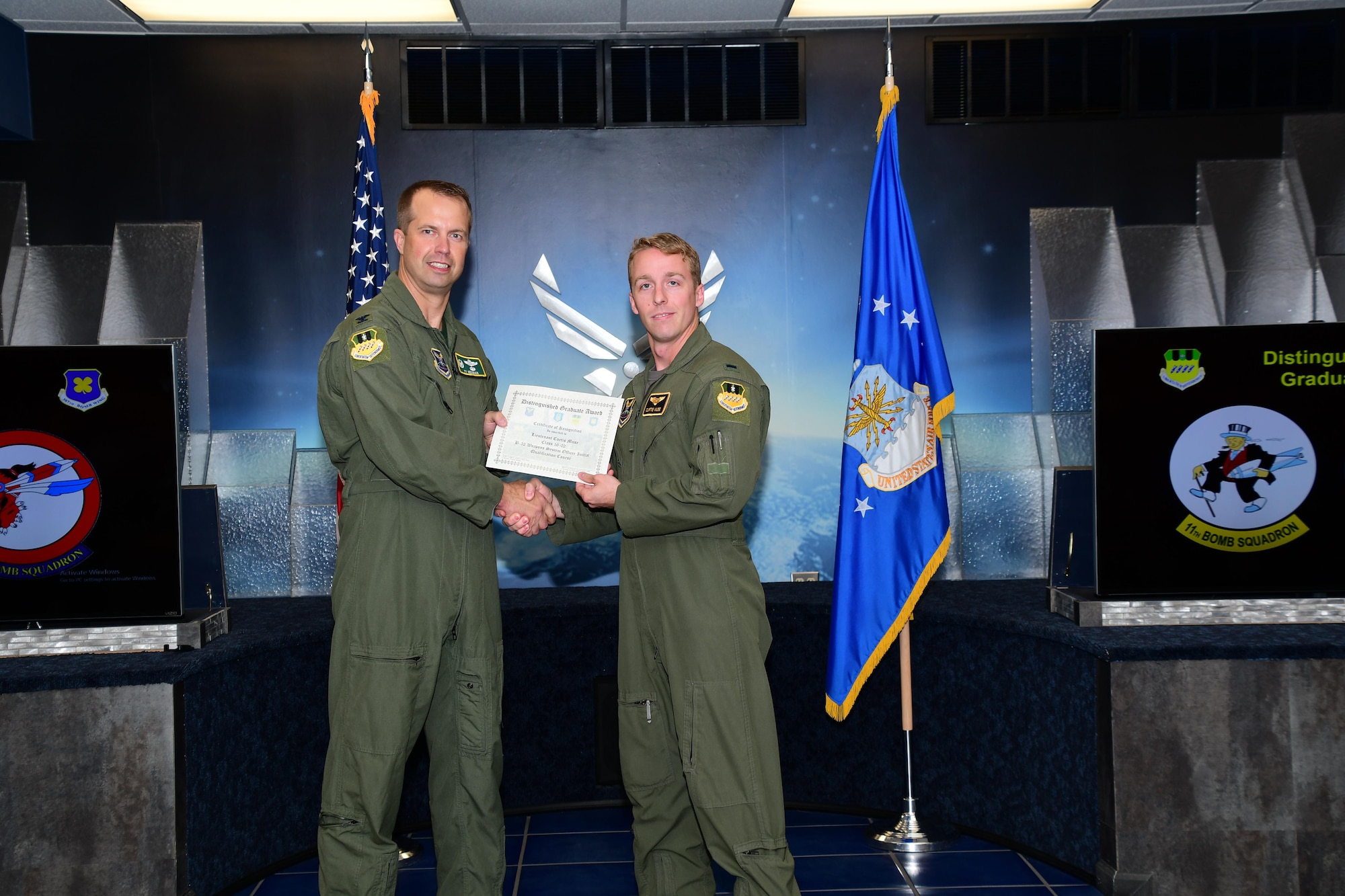 U.S. Air Force Col. Ty Neuman, commander of the 2nd  Bomb Wing, presents the Weapons Systems Officer Distinguished Graduate Award to 1st Lt. Curtis Muse during a Formal Training Unit (FTU) graduation ceremony, Barksdale Air Force Base, La. Muse graduated from the FTU as an Electronic Warfare Officer on the B-52H Stratofortress. (U.S. Air Force photo by Master Sgt. Laura Siebert /Released)