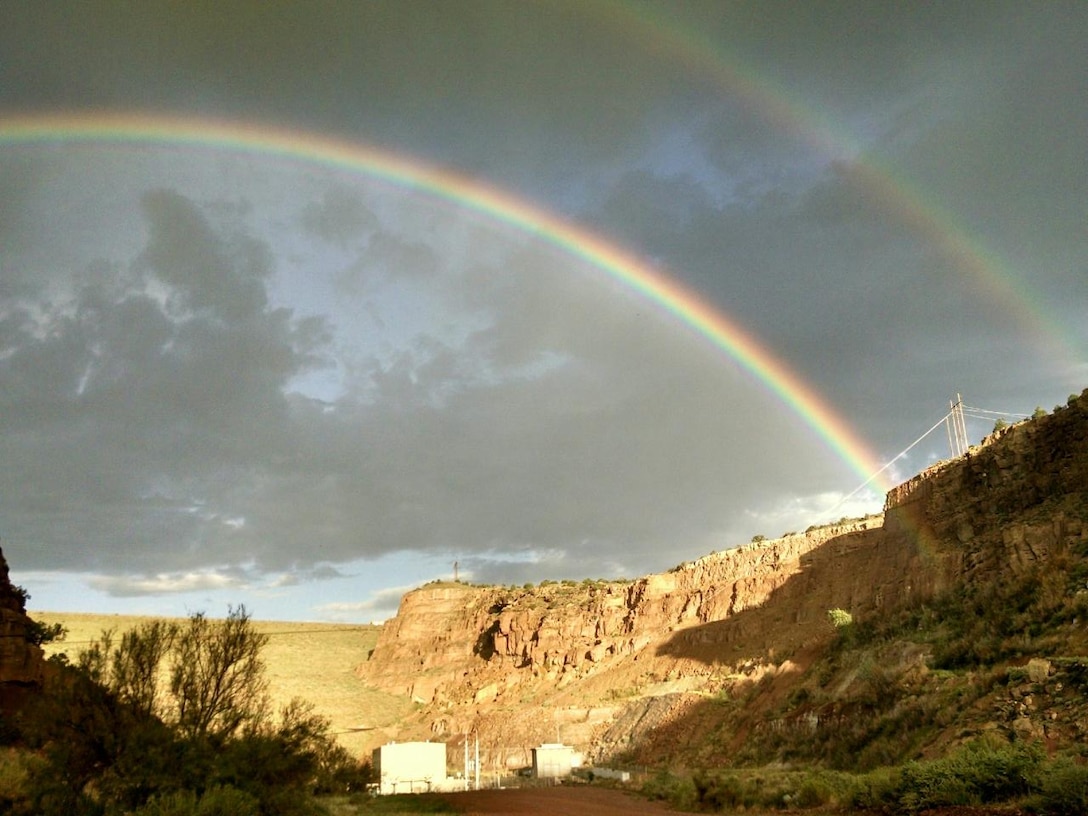 ABIQUIU DAM, N.M – Looking up from the downstream side of the dam alongside the Rio Chama, two rainbows appear in the sky after a passing storm, Sept. 1, 2016. Photo by Clarence Maestas. This 2016 Photo Drive entry tied for second place based on employee voting.