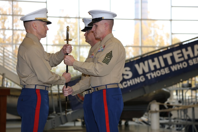 The 9th Marine Corps District commanding officer, Col. Jason Morris, and Sgt. Maj. John S. Hawes, pass the noncommissioned officer sword during the relief and appointment ceremony aboard Naval Station Great Lakes, Ill., on Nov. 18, 2016. The emblematic passing of the sword of office signifies the transfer of sacred trust from one sergeant major to another. (U.S. Marine Corps photo by Cpl. Zachery Martin/Released)