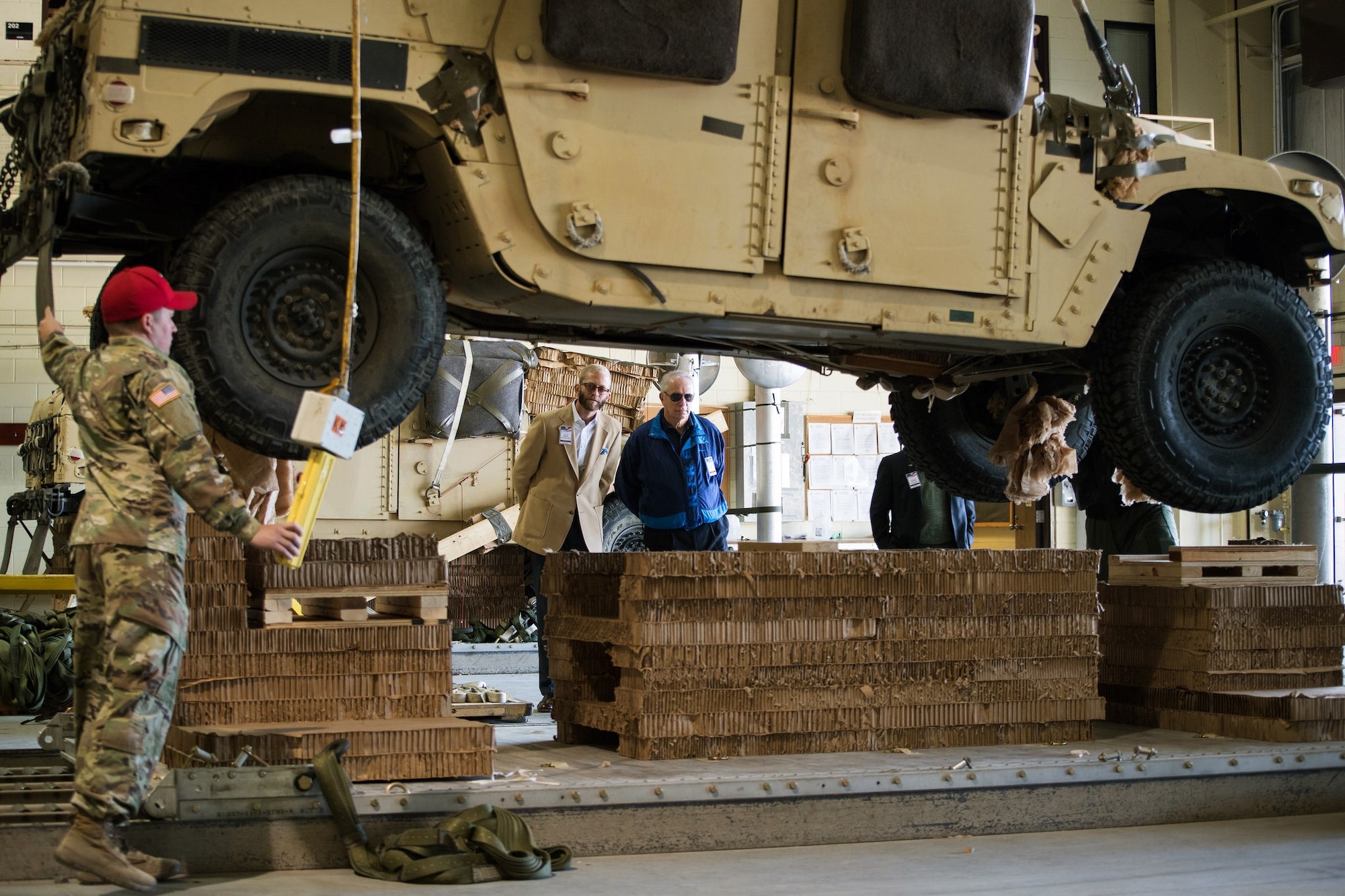 A Soldier from the 189th Combat Sustainment Support Battalion demonstrates how a Humvee is rigged for airborne operations Nov. 16, 2016 at the Heavy Drop Rigging Facility on Pope Army Airfield, N.C. The demonstration was part of the AMC civic leader tour of the AMC mission at Pope AAF.  The tour provided insight into AMC’s prominent role enabling joint mission effects globally. (U.S. Air Force photo by Marc Barnes)