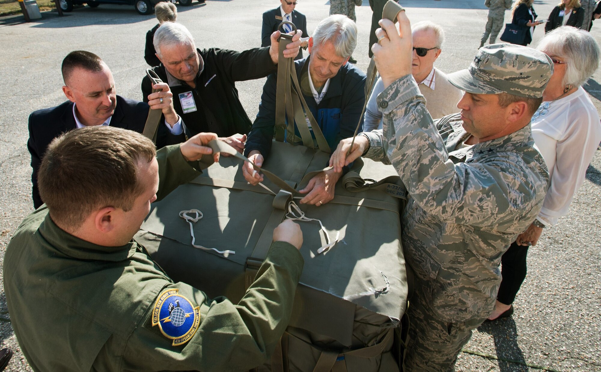 Maj. Gen. Thomas Sharpy, AMC vice commander, works with AMC civic leaders to build a Container Delivery System bundle, Nov. 16, 2016 during a civic leader tour at the 43rd Operations Support Squadron at Pope Army Airfield, N.C. The visit was part of the AMC civic leader tour of the AMC mission at Pope AAF.  The tour provided insight into AMC’s prominent role enabling joint mission effects globally. (U.S. Air Force photo by Marc Barnes)