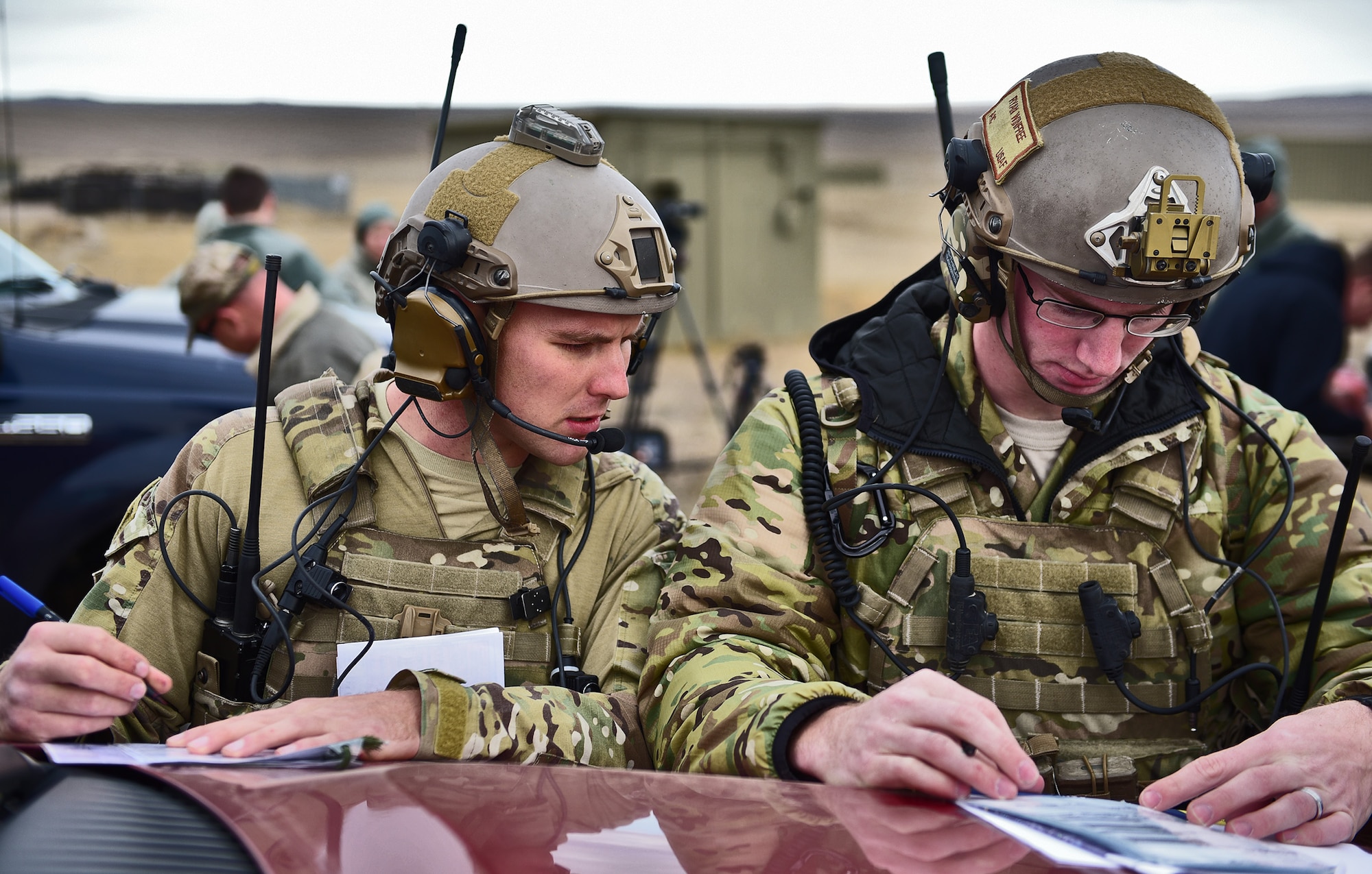Airman 1st Class Ethan Gossett and Senior Airman Ryan Winfree, joint terminal attack controllers assigned to the 5th Air Support Operations Squadron, Joint Base Lewis-McChord, Wash., double check their numbers before a B-1 flyover near Belle Fourche, S.D., Nov. 16, 2016. JTAC members direct the action of combat aircraft engaged in close-air-support and other offensive air operations from a forward position. (U.S. Air Force photo by Airman 1st Class James L. Miller) 