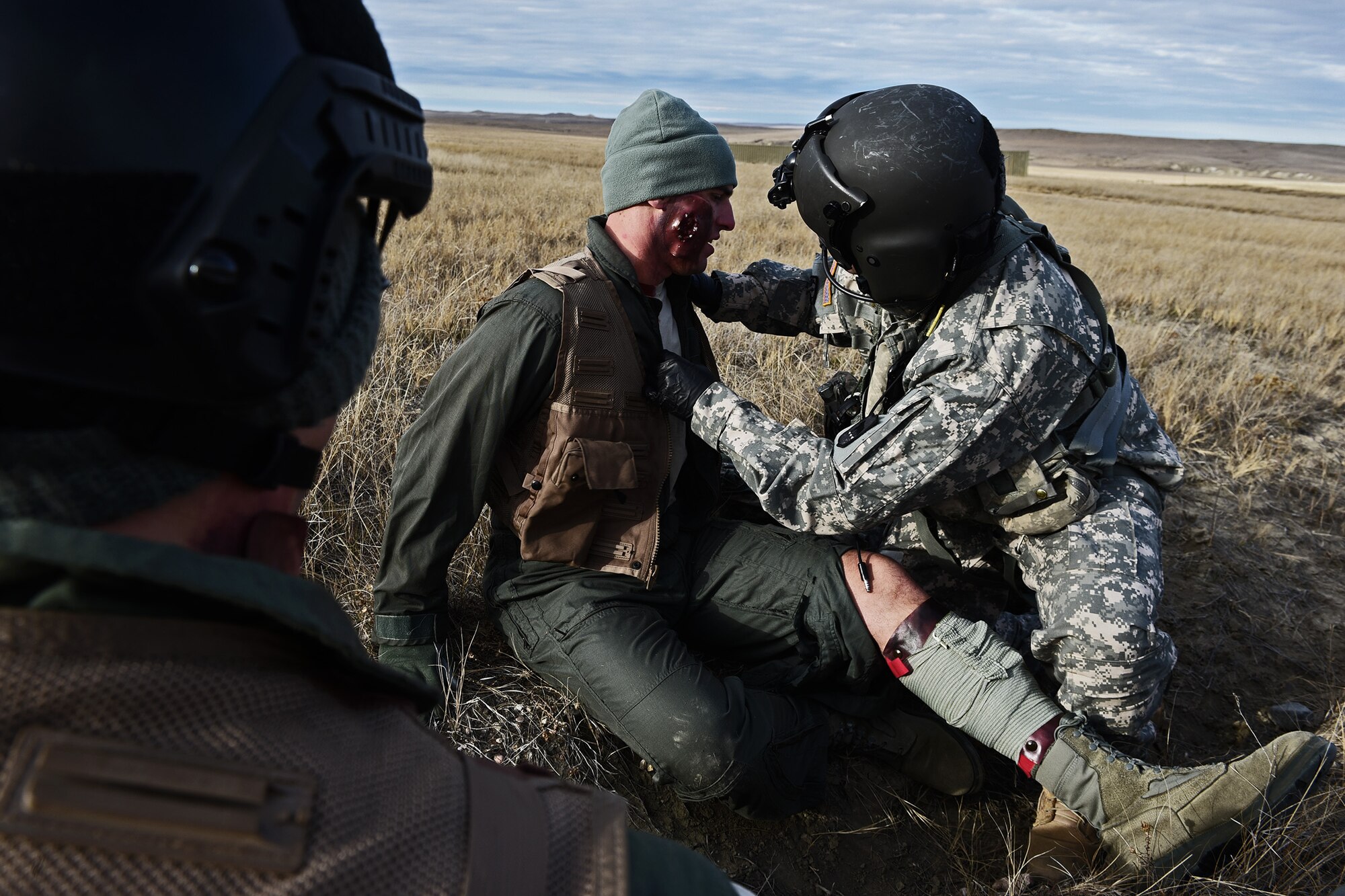 A soldier from the South Dakota National Guard’s Company C, 1st Battalion, 189th Aviation Regiment, provides medical care to a downed B-1 pilot near Belle Fourche, S.D., Nov. 16, 2016. The training scenario involved a show of force, followed by a rescue helicopter to evacuate the injured pilots. (U.S. Air Force photo by Airman 1st Class James L. Miller)