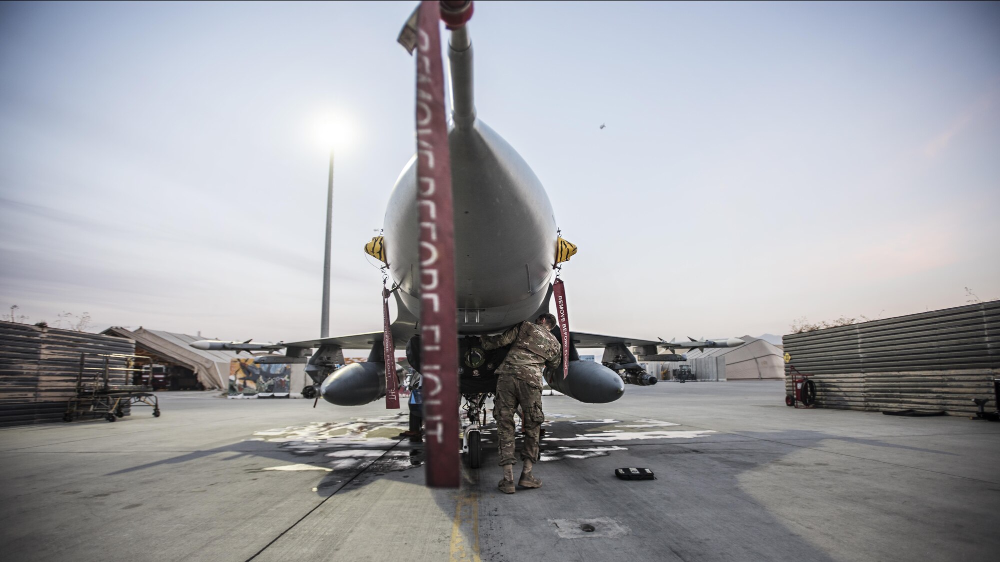 Senior Airman Daniel Lasal, 455th Expeditionary Aircraft Maintenance Squadron dedicated crew chief, replaces an intake cover on an F-16 Fighting Falcon Nov. 15, 2016 at Bagram Airfield, Afghanistan. Lasal is an aircraft maintainer responsible for ensuring his assigned jet flies properly. (U.S. Air Force photo by Staff Sgt. Katherine Spessa)