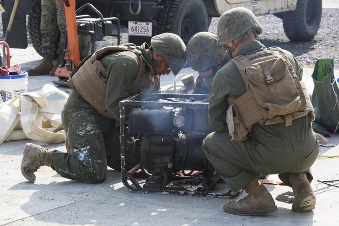 U.S. Marine Corps Lance Cpls. Jorge Lares, left, Ashley Garcia, middle, and Austin Berube, right, combat engineers with Marine Wing Support Squadron (MWSS) 171, attempt to fix a generator during unit level training at Marine Corps Air Station Iwakuni, Japan, Nov. 17, 2016. The focused on base recovery exercises to better prepare the Marines for scenarios that could arise while on station or during deployment. (U.S. Marine Corps photo by Lance Cpl. Joseph Abrego)