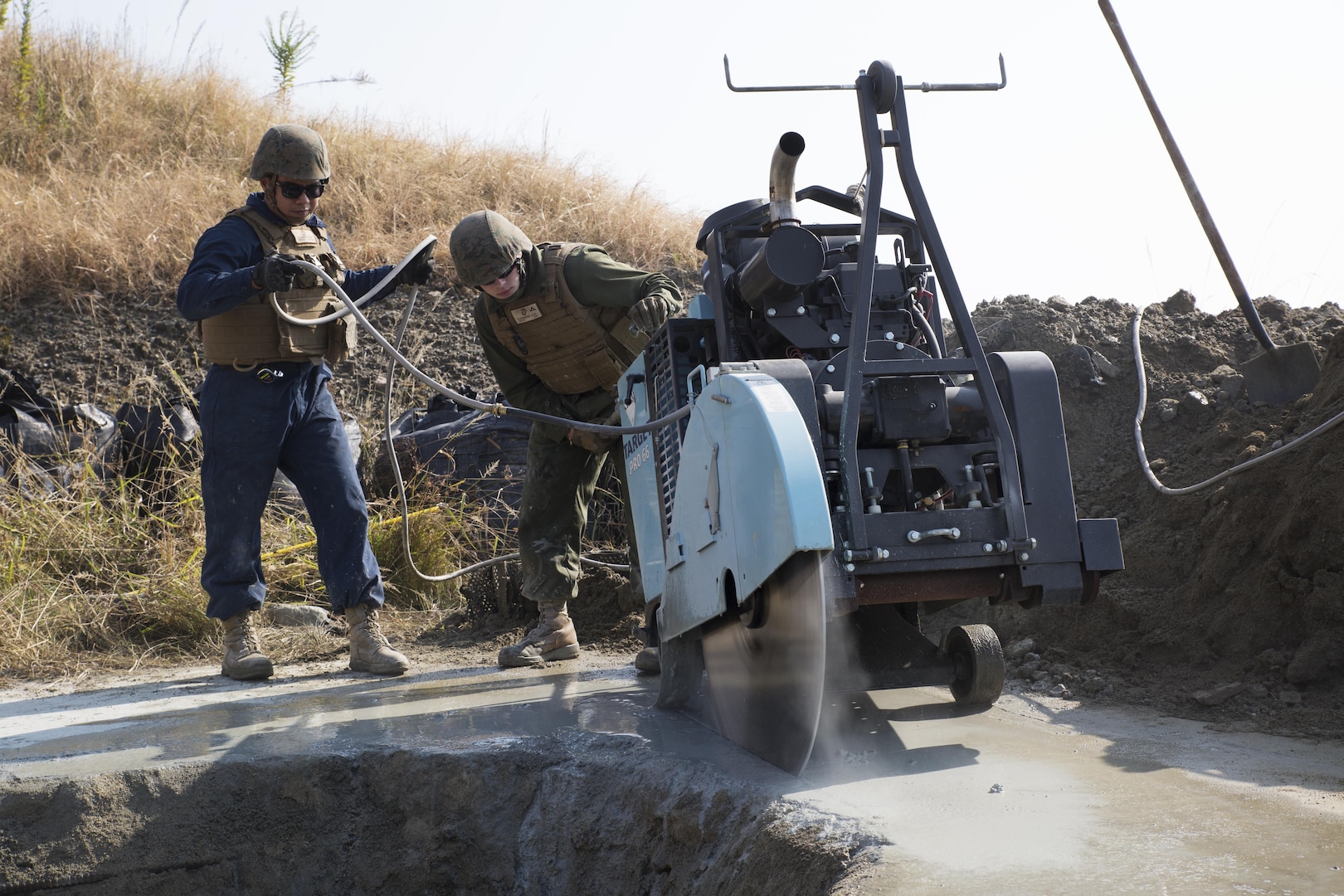 U.S. Marine Corps Lance Cpls. Jorge Lares, left, and Kendal Kleinhenz, right, combat engineers with Marine Wing Support Squadron (MWSS) 171, use a walk behind concrete saw to simulate repairs to a damaged runway during unit level training at Marine Corps Air Station Iwakuni, Japan, Nov. 17, 2016. The training focused on base recovery exercises to better prepare the Marines for scenarios that could arise while on station or during deployment. (U.S. Marine Corps photo by Lance Cpl. Joseph Abrego)