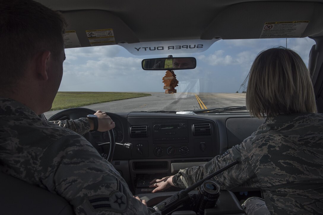 U.S. Air Force Senior Airman Monika Neal and Airman 1st Class Caleb Berstler, 18th Operations Support Squadron airfield management operations coordinators, drive and honk at a flock of birds to scare them off the runway Nov. 16, 2016, at Kadena Air Base, Japan. Keeping wildlife off the runways is vital to the safety of aircraft and their crews. (U.S. Air Force photo by Airman 1st Class Corey M. Pettis/Released)