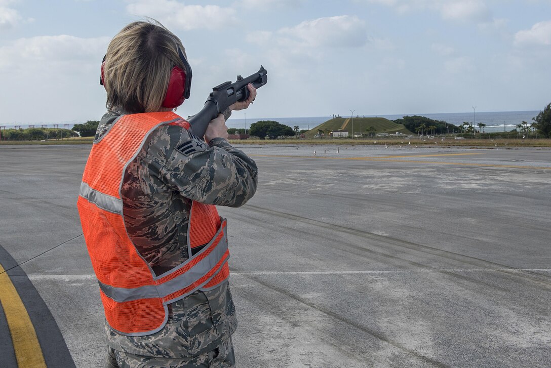 U.S. Air Force Senior Airman Monika Neal, 18th Operations Support Squadron airfield management operations coordinator, shoots a pyrotechnic round at a flock of birds to scare them off the runway Nov. 16, 2016, at Kadena Air Base, Japan. Birds and other wildlife can be sucked into the engines of aircraft and cause severe damage. (U.S. Air Force photo by Airman 1st Class Corey M. Pettis/Released)