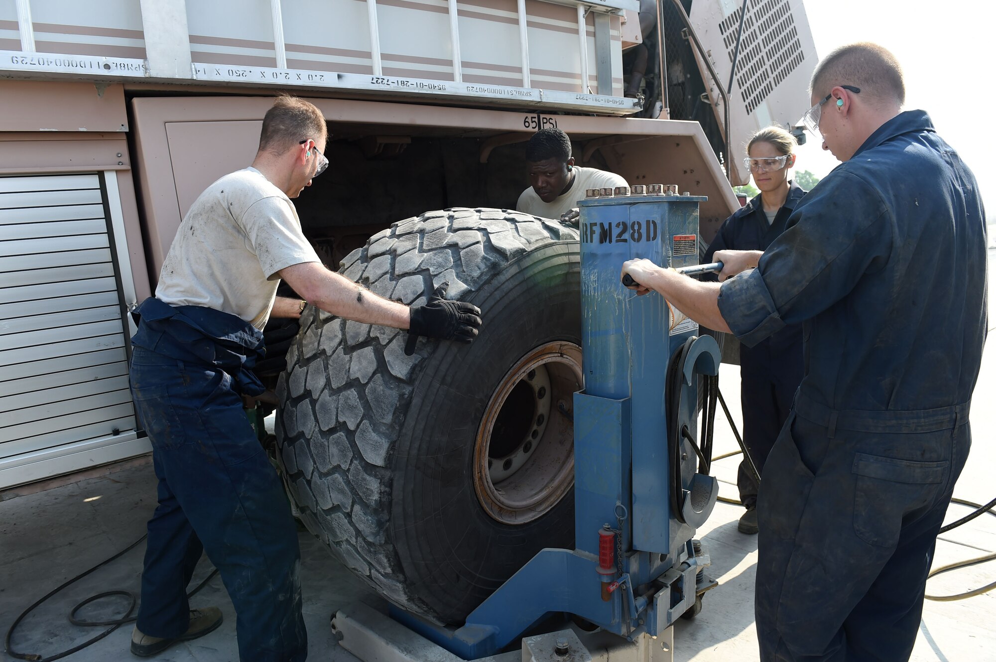Col. Kevin Eastland, 380th Air Expeditionary Wing vice commander, works with Senior Airman Alex, 380th Fire and Refueler Maintenance vehicle maintainer, to pull a tire from a fire truck onto a lift system operated by Staff Sgt. Alex, 380th FARM vehicle maintainer, at an undisclosed location in Southwest Asia, November 16, 2016. FARM vehicle maintainers are responsible for ensuring that all fire and fuel trucks are operational and mission ready. (U.S. Air Force photo by Tech. Sgt. Christopher Carwile) 