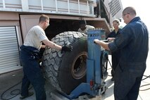 Col. Kevin Eastland, 380th Air Expeditionary Wing vice commander, works with Senior Airman Alex, 380th Fire and Refueler Maintenance vehicle maintainer, to pull a tire from a fire truck onto a lift system operated by Staff Sgt. Alex, 380th FARM vehicle maintainer, at an undisclosed location in Southwest Asia, November 16, 2016. FARM vehicle maintainers are responsible for ensuring that all fire and fuel trucks are operational and mission ready. (U.S. Air Force photo by Tech. Sgt. Christopher Carwile) 