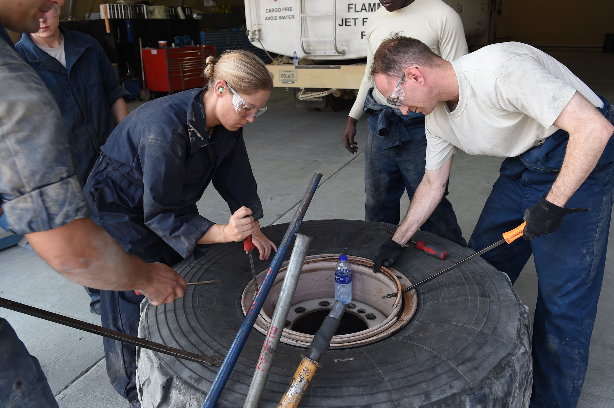 Col. Kevin Eastland, 380th Air Expeditionary Wing vice commander, and Capt. Jennifer, 380th AEW executive officer, work together to remove the lock ring from a fire truck tire rim at an undisclosed location in Southwest Asia, November 16, 2016. Senior Airman Alex, 380th Fire and Refueler Maintenance vehicle maintainer, claimed that Jennifer had one of the fastest lock ring removal times than most people he has seen, and vowed to steal some of her techniques. (U.S. Air Force photo by Tech. Sgt. Christopher Carwile)