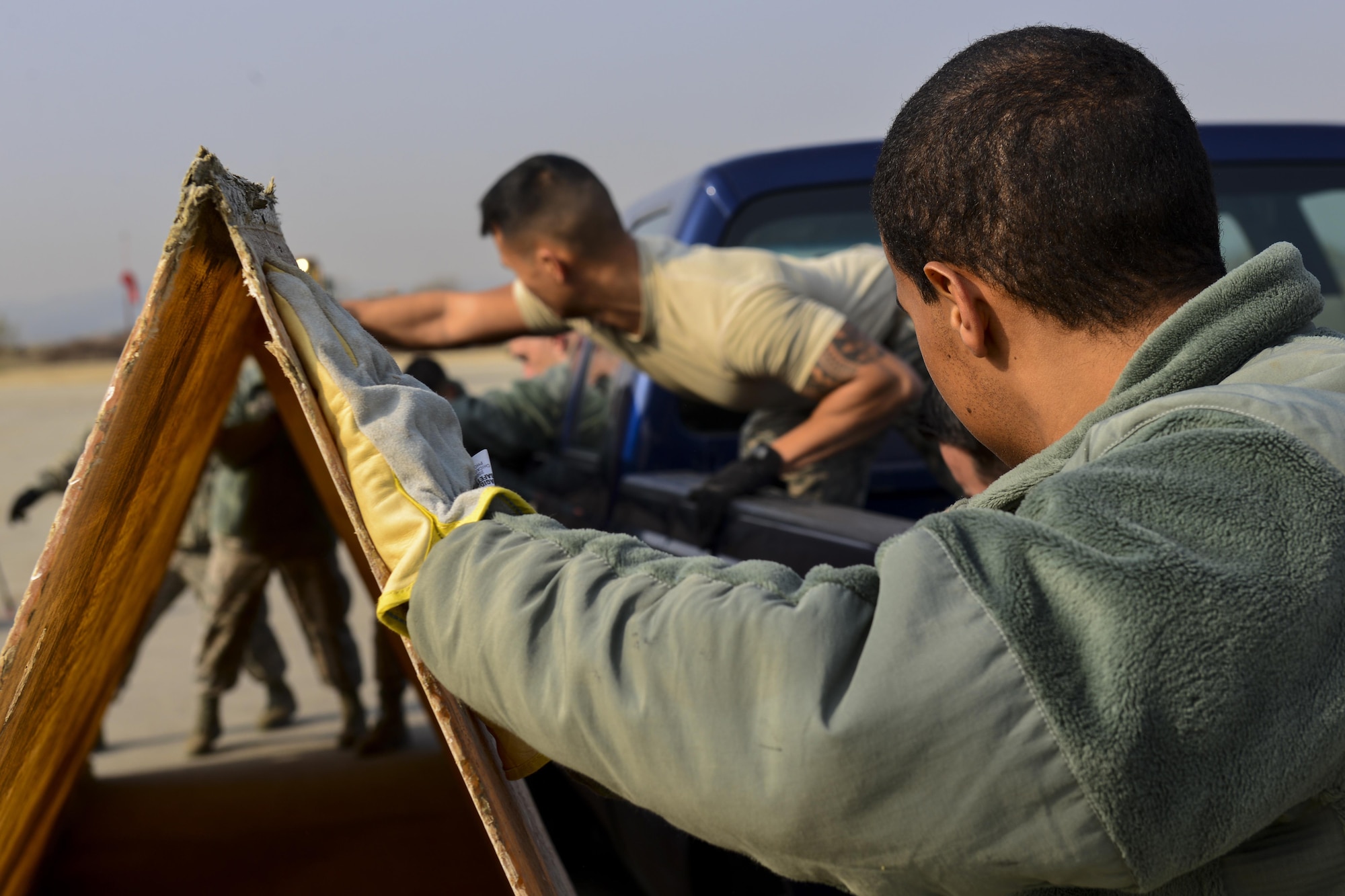 Airmen from the 51st Civil Engineer Squadron structures flight consolidate a folded fiberglass matt during Prime BEEF Day at Osan Air Base, Republic of Korea, Nov. 17, 2016. Folded fiberglass matts are used to help reinforce damaged runways during contingency operations, with the ability to withstand the weight of a landing aircraft without fracturing. (U.S. Air Force photo by Senior Airman Victor J. Caputo)
