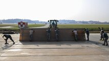Airmen from the 51st Civil Engineer Squadron structures flight consolidate a folded fiberglass matt during Prime BEEF Day at Osan Air Base, Republic of Korea, Nov. 17, 2016. Folded fiberglass matts are used to help reinforce damaged runways during contingency operations, with the ability to withstand the weight of a landing aircraft without fracturing. (U.S. Air Force photo by Senior Airman Victor J. Caputo)