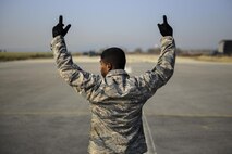 U.S. Air Force Senior Airman Jisen Abraham, 51st Civil Engineer Squadron operations facilities power craftsman, coordinates between two teams of Airmen operating both sides of a mobile aircraft arresting system at Osan Air Base, Republic of Korea, Nov. 17, 2016. Once the aircraft arresting system cable was extended, Abraham ensured both sides were retracted simultaneously. (U.S. Air Force photo by Senior Airman Victor J. Caputo)