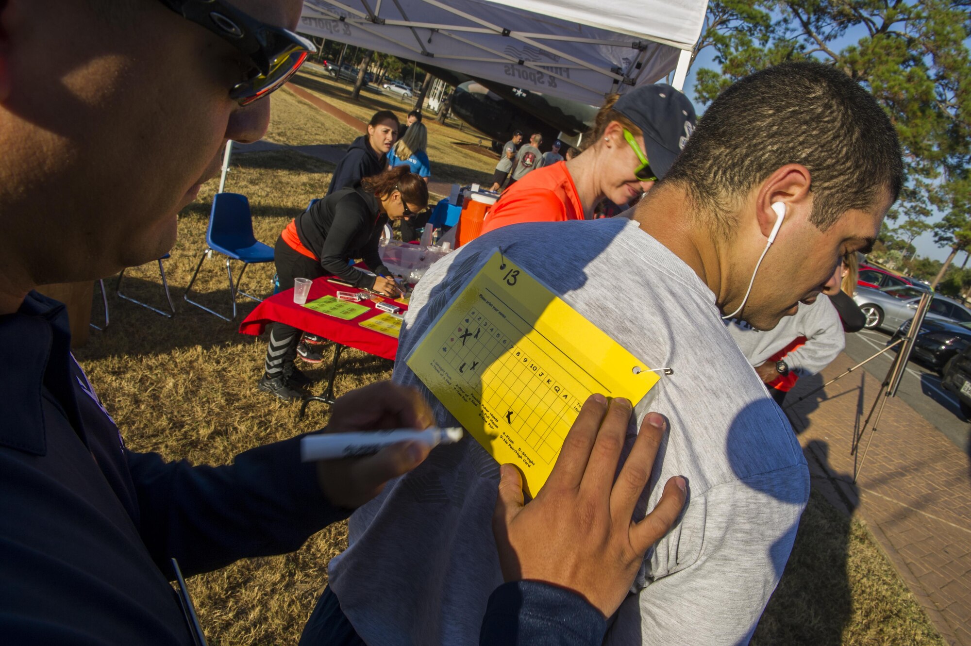 Tech. Sgt. Christian Pagan, the Aderholt fitness manager with the 1st Special Operations Force Support Squadron, marks a runner’s card for the poker portion of the Turkey Trot Poker Run 5K at Hurlburt Field, Fla., Nov. 18, 2016. Prizes included turkeys, speakers and gift certificates, and were given to the best male and female runner, the best poker hand and raffle winners. (U.S. Air Force photo by Airman 1st Class Isaac O. Guest IV)