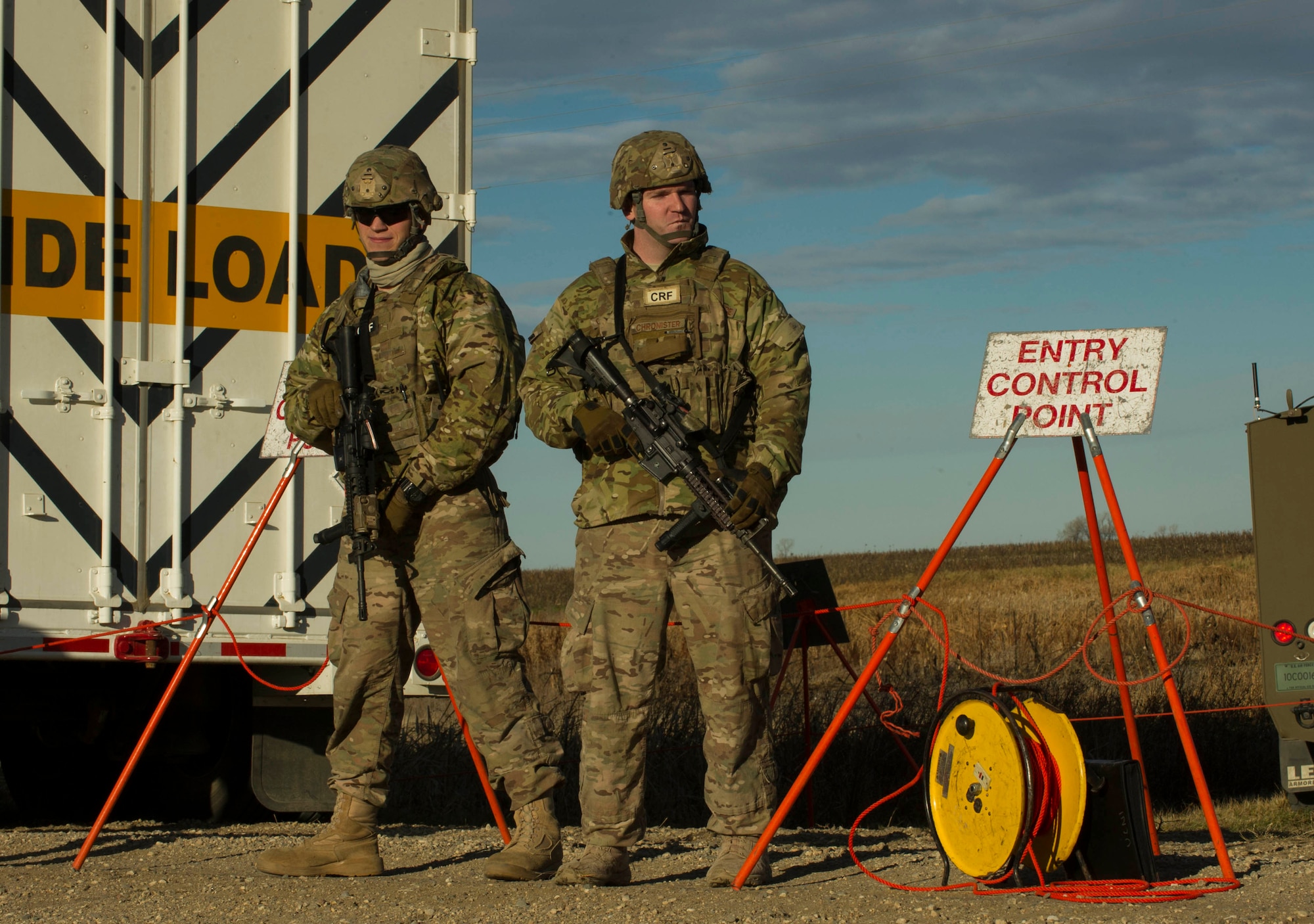 (From left) Senior Airman Dustin Silc and Staff Sgt. Tyler Chronister, 791st Missile Security Forces Squadron convoy response force members, provide security at an entry control point during a recapture and recovery exercise at the missile complex, N.D., Nov. 16, 2016. A cordon was set as part of a simulated hostile takeover training exercise. (U.S. Air Force photo/Senior Airman Apryl Hall)