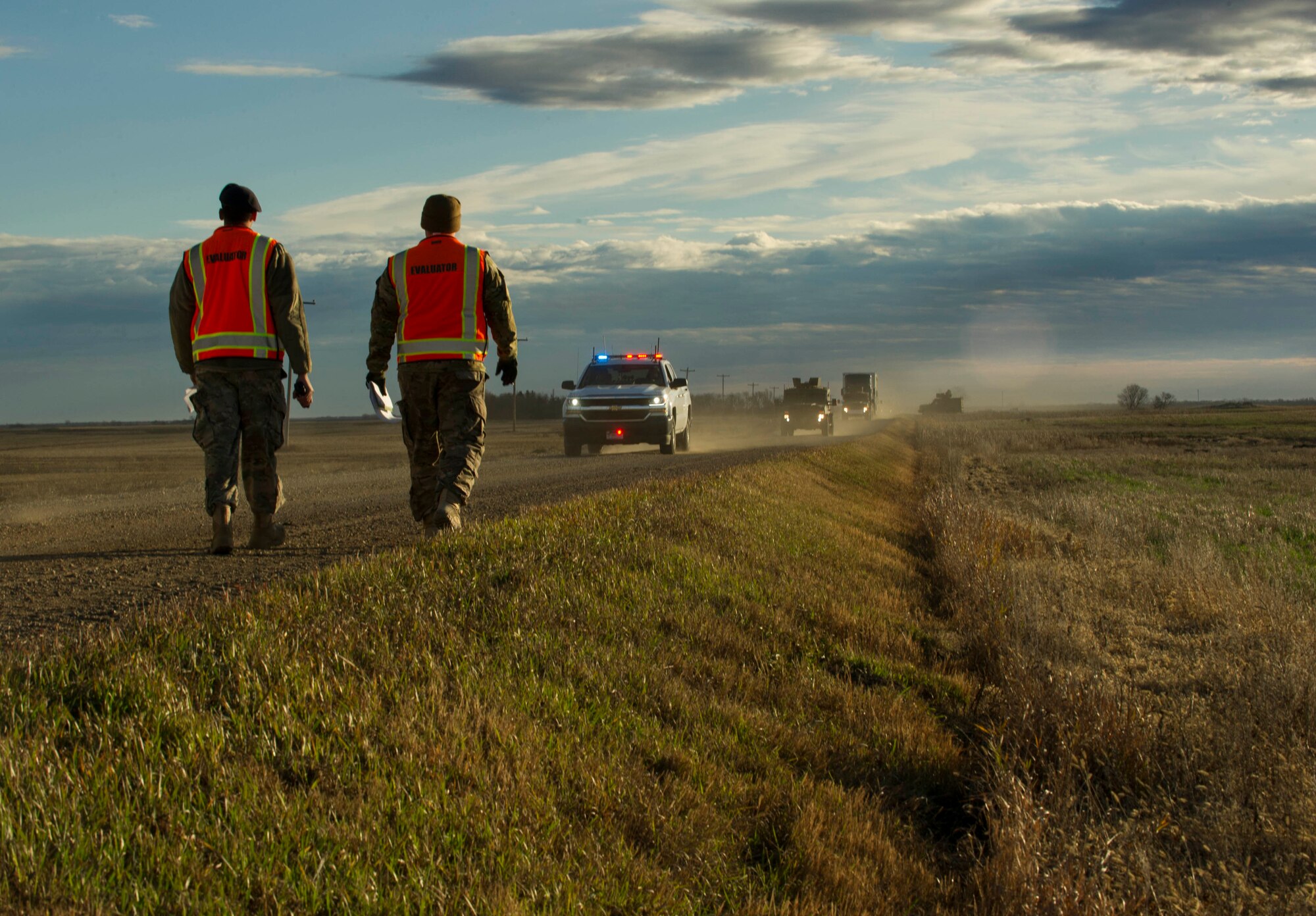 Evaluators walk toward a convoy during a recapture and recovery exercise at the missile complex, N.D., Nov. 16, 2016. Evaluators observed the exercise to ensure all proper procedures were taken during the scenario, which simulated hostile forces taking over a payload transporter. (U.S. Air Force photo/Senior Airman Apryl Hall)