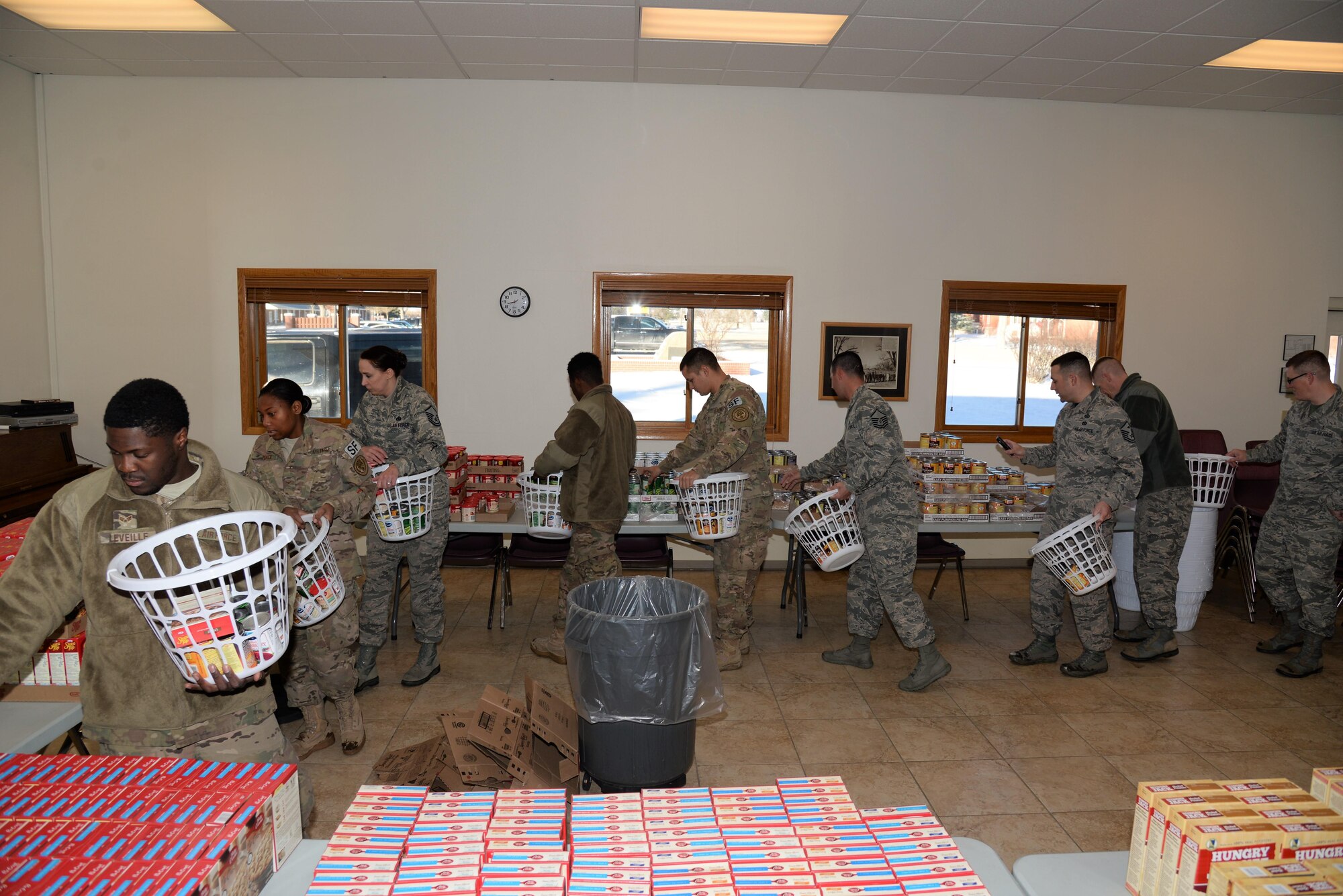First sergeant council volunteers form an assembly line to quickly and efficiently build Thanksgiving baskets in the High Plains chapel at F.E. Warren Air Force Base, Wyo., Nov. 18, 2016.  Volunteers put together 125 baskets equipped with everything needed to provide a complete meal, including a gift card to purchase a turkey. The baskets will be delivered to junior-ranking Airmen, selected by their chain of command, to ensure their families are able to enjoy a Thanksgiving meal for the holiday. (U.S. Photo by 2d Lt. Nikita Thorpe)