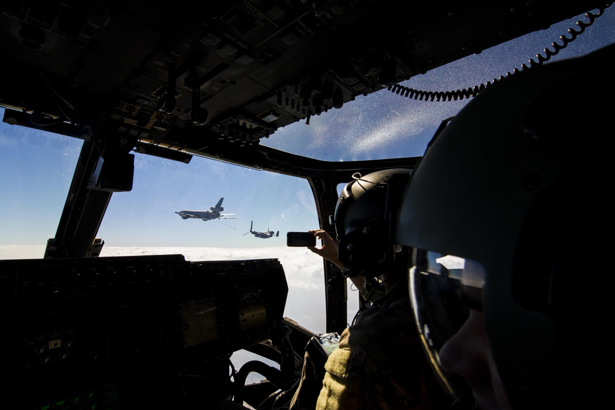 An Air Commando with the 8th Special Operations Squadron observes as a CV-22 Osprey tiltrotor aircraft approaches a KC-10 Extender air-refueling receptacle during a training mission over the Gulf of Mexico, Nov. 18, 2016. The air-refuel mission marked the first time an 8th SOS aircraft has connected to a KC-10. (U.S. Air Force photo by Airman 1st Class Joseph Pick)