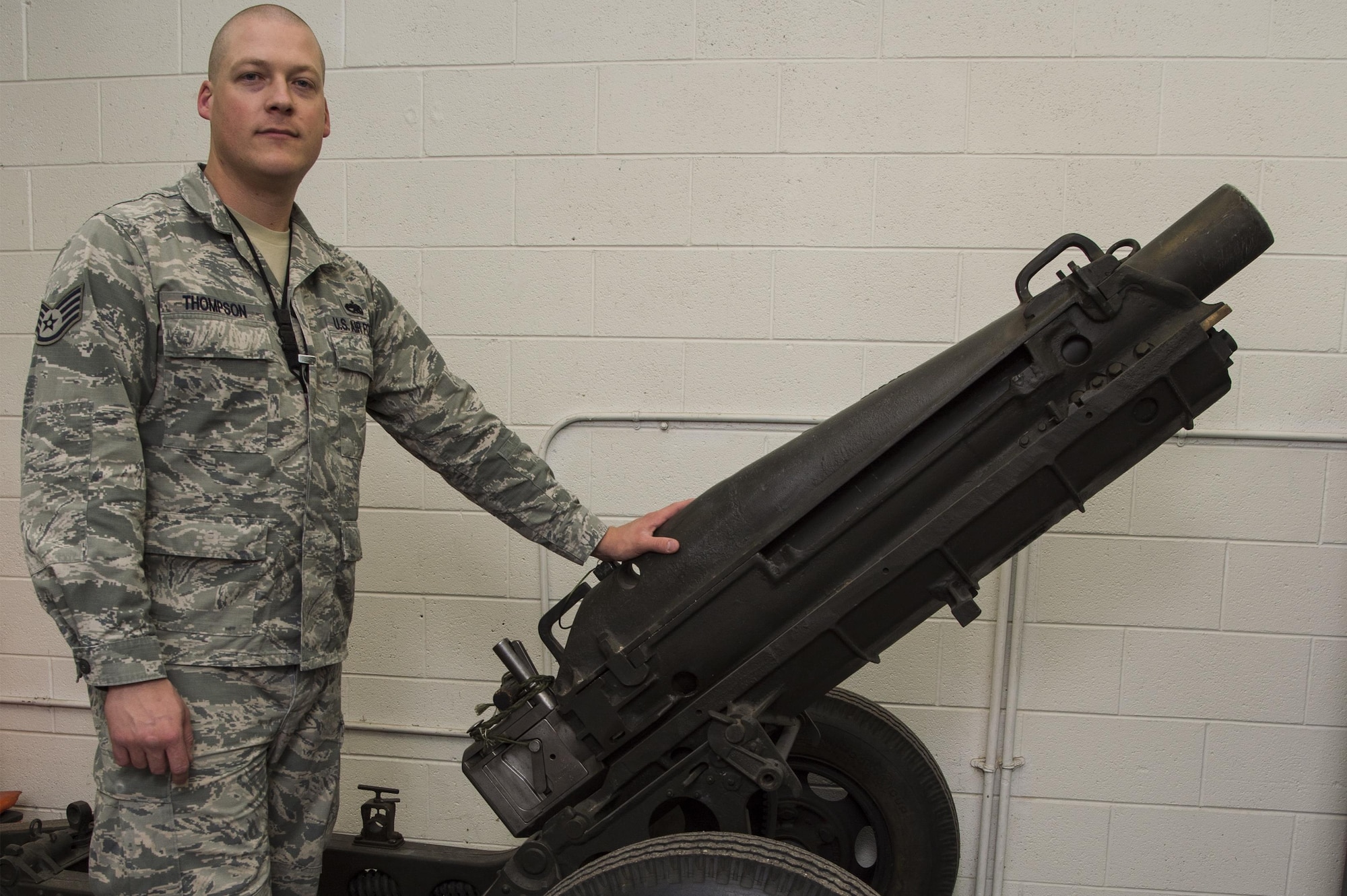 Staff Sgt. Bryan Thompson, 90th Munition Squadron munitions operations NCO in charge, stands beside a M1 Pack Howitzer artillery cannon at F.E. Warren Air Force Base, Wyo., Oct. 31, 2016. This is the last remaining active duty Air Force artillery cannon still in use today for official ceremonies on the base. The 90th MUNS mission is to enable nuclear deterrence by maintaining combat ready munitions in defense of global freedoms safely, securely and effectively. (U.S. Air Force photo by Staff Sgt. Christopher Ruano) 