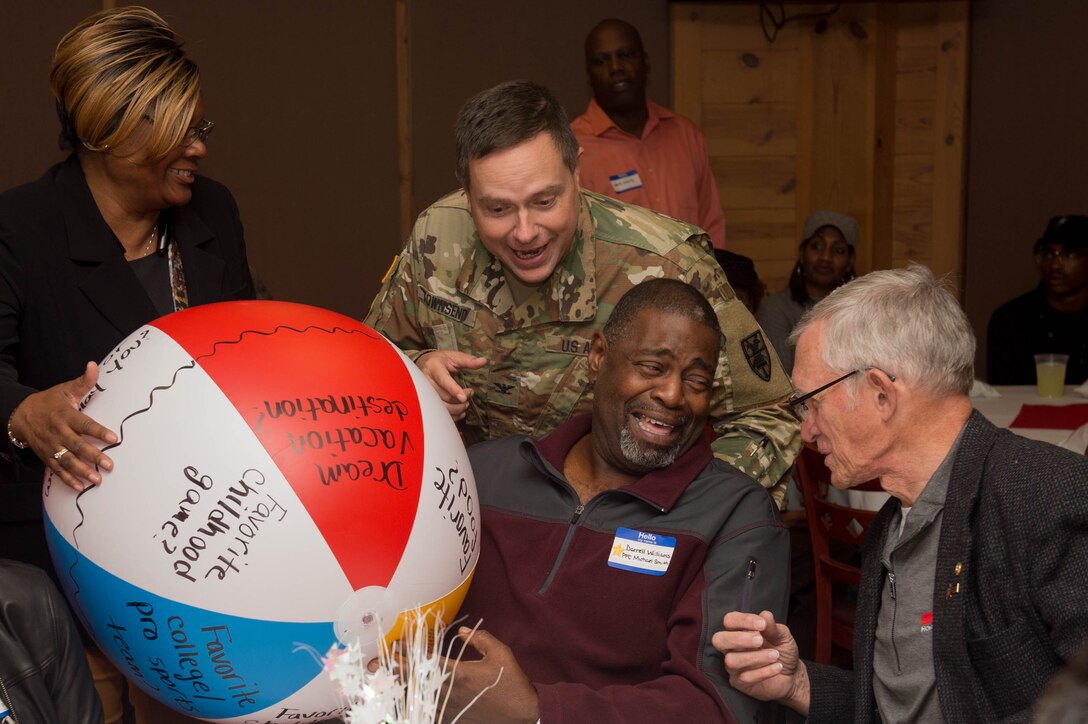 U.S. Army Col. Stacy Townsends, 7th Transportation Battalion commander, interacts with members of Survivor Outreach Services during the Thanks for Giving Potluck at Joint Base Langley-Eustis, Va., Nov. 17, 2016. Attendees were served Thanksgiving dinner and received entertainment by a comedian, a ventriloquist and a singer throughout the night. (U.S. Air Force photo by Airman 1st Class Derek Seifert)