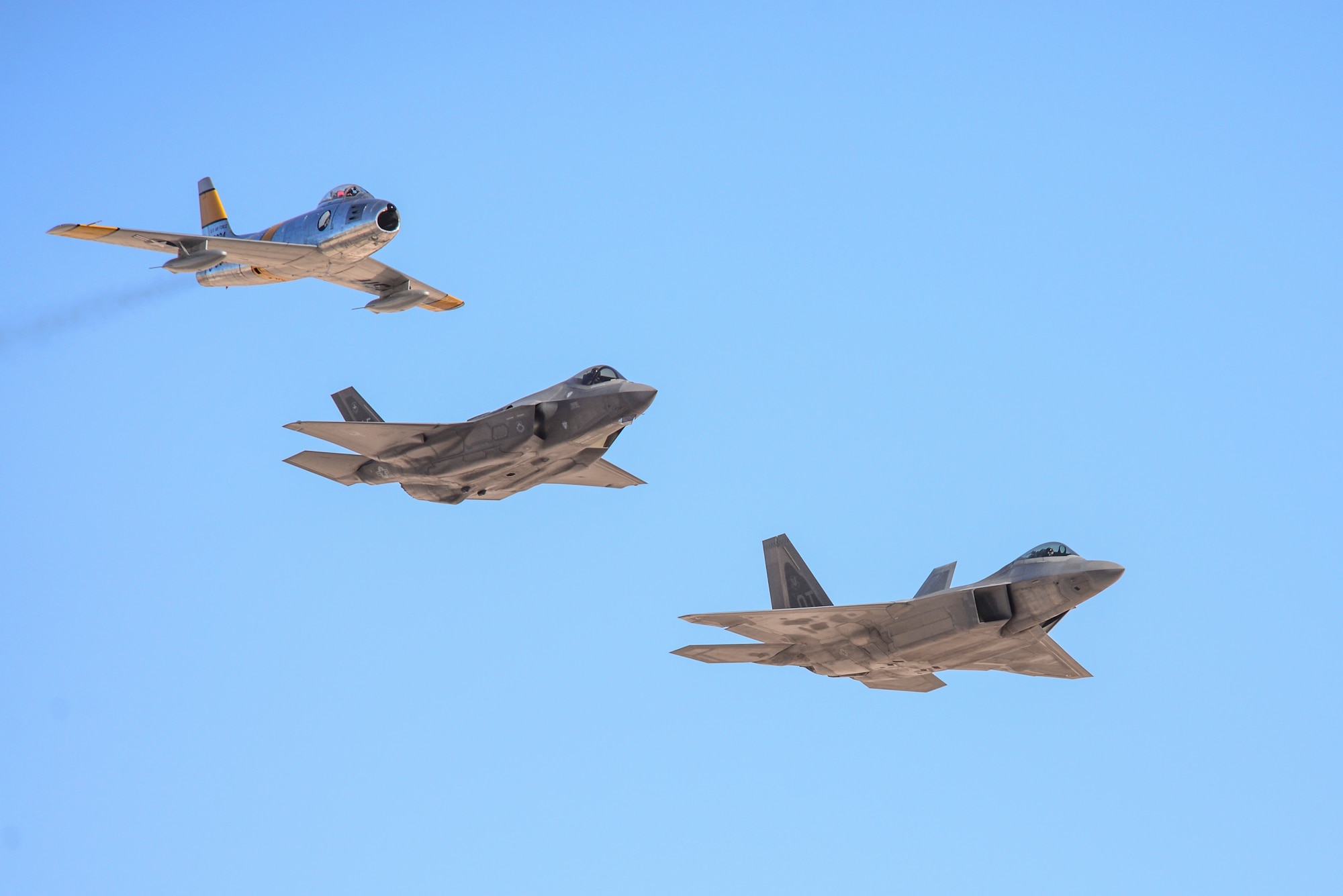 The U.S. Air Force F-22 Raptor Demonstration Team participates in the Heritage Flight formation with the F-35 Lightening II and F-18 Saber at the 2016 Air Power over Southern Nevada Air Show at Nellis Air Force Base, Nev., Nov. 13, 2016.  The Heritage Flight is a group of pilots who fly various aircraft together to pay homage to the evolution of aviation. (U.S. Air Force photo by 2nd Lt. Mahalia Frost)