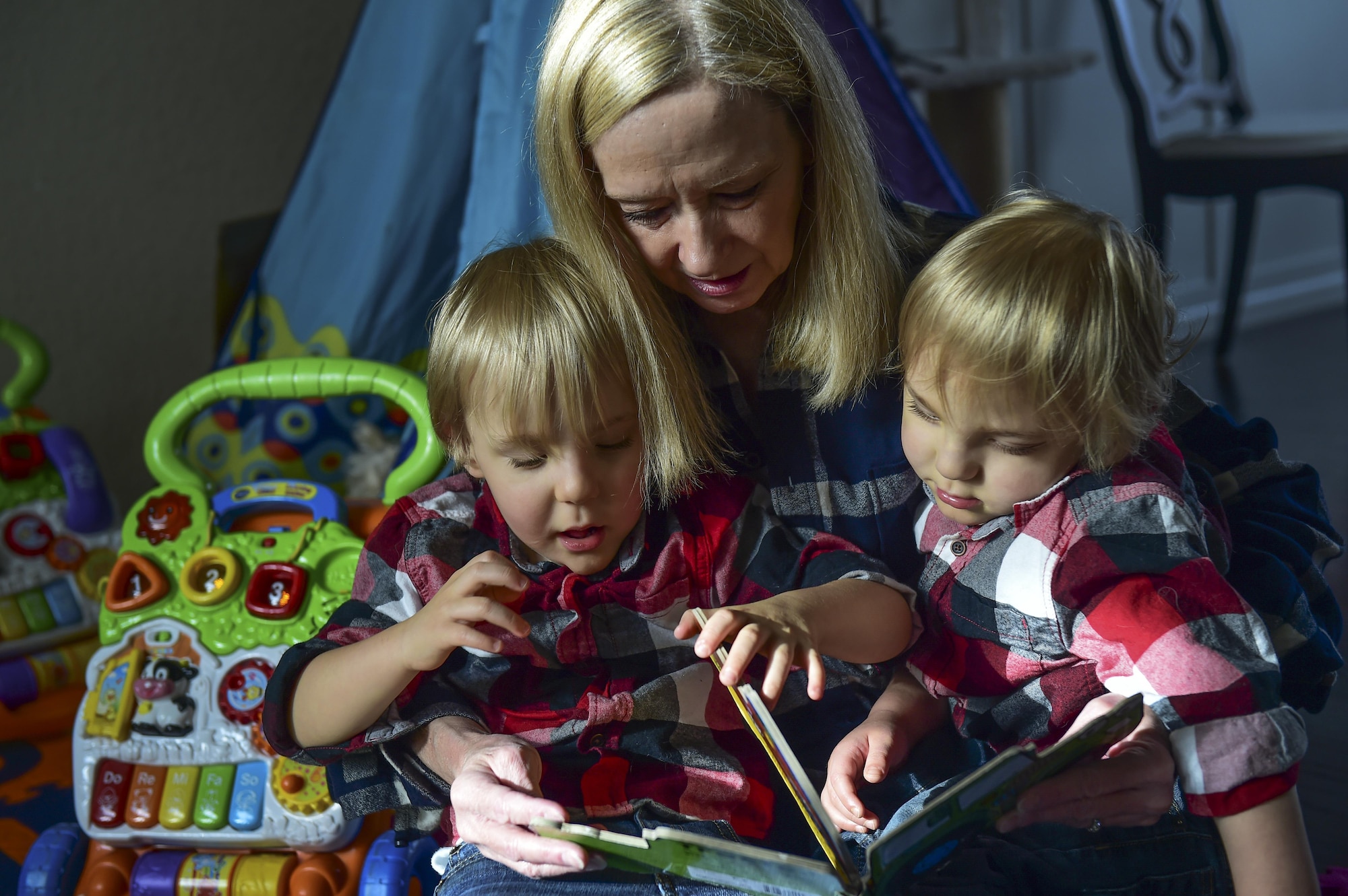 Robbie Wren-a Aswegan reads a book to her grandsons during their third birthday party Nov. 2, 2016, at the Douglas family home in Colorado Springs, Colo. The twins, born premature at 23 weeks, 17 weeks earlier than normal have experienced various physical trials along their journey through life. (U.S. Air Force photo by Airman 1st Class Gabrielle Spradling/Released)
