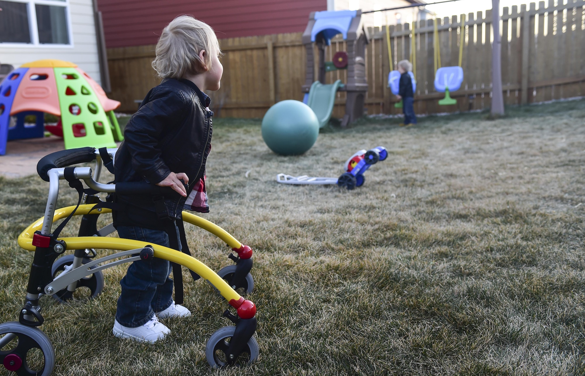 Dean Fredric Douglas watches his twin brother, Luke James Douglas, play on a swing set Nov. 2, 2016, at their family home in Colorado Springs, Colo. Both Dean and Luke suffered complications during a premature birth at 23 weeks, however, Dean is much more limited because he had several brain bleeds that caused him to have cerebral palsy in his legs. (U.S. Air Force photo by Airman 1st Class Gabrielle Spradling/Released)