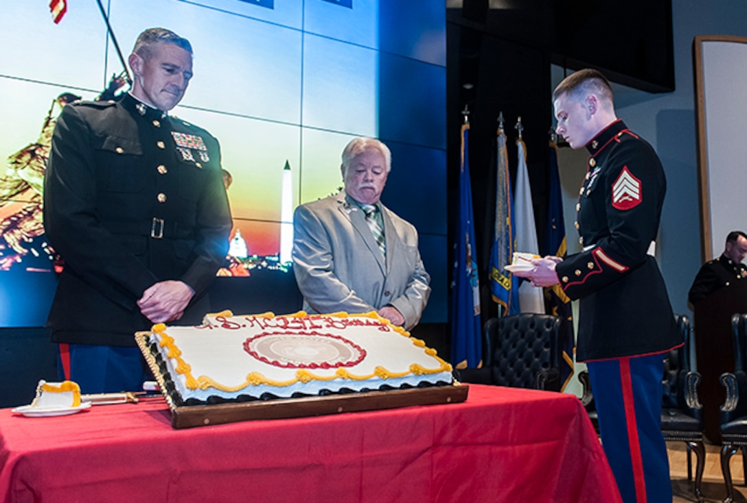 Oldest Marine Sgt. Gary A. Rodgers passes cake to Sgt. Austin Reed, the youngest Marine during the cake cutting ceremony that serves as the hallmark of the Marine Corps birthday ceremony.