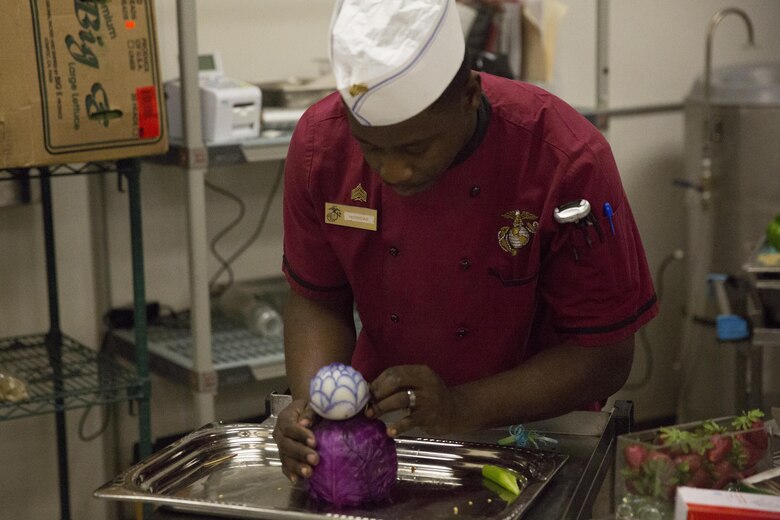 Sgt. Steven Homidas, chief cook, constructs a garnish during preparation for the Marine Corps birthday meal at Phelps Mess Hall, Nov. 10, 2016. The Marine Corps’ birthday is one of the many traditions that Marines take great pride in celebrating annually. (Official Marine Corps photo be Cpl. Medina Ayala-Lo/Released)