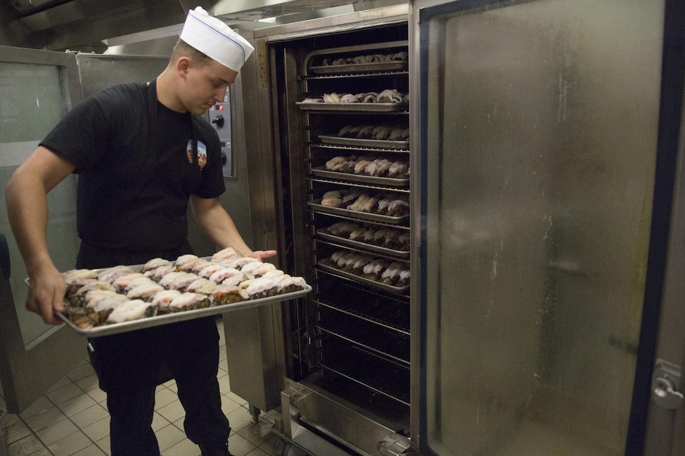 Lance Cpl. Kenneth Martin, food service specialist, Headquarters Battalion, places lobster tails in the oven during preparation for the Marine Corps birthday meal at Phelps Mess Hall, Nov. 10, 2016. The Marine Corps’ birthday is one of the many traditions that Marines take great pride in celebrating annually. (Official Marine Corps photo be Cpl. Medina Ayala-Lo/Released)