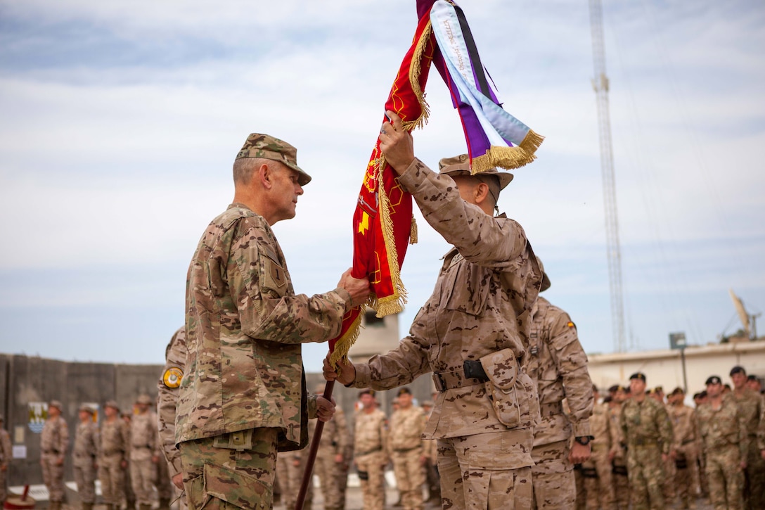 U.S. Army Brig. Gen. William Turner, left, deputy commanding general, 1st Infantry Division, receives the guidon from the Spanish commander during the transfer of authority to the fifth Spanish contingent at the Besmaya Range Complex, Iraq, Nov. 18, 2016. The Spanish army provides specialist training at Camp Besmaya, one of four Combined Joint Task Force – Operation Inherent Resolve (CJTF-OIR) building partner capacity locations dedicated to training Iraqi security forces. Combined Joint Task Force-Operation Inherent Resolve is a multinational effort to weaken and destroy Islamic State in Iraq and the Levant operations in the Middle East region and around the world  (U.S. Army photo by Sgt. Josephine Carlson)