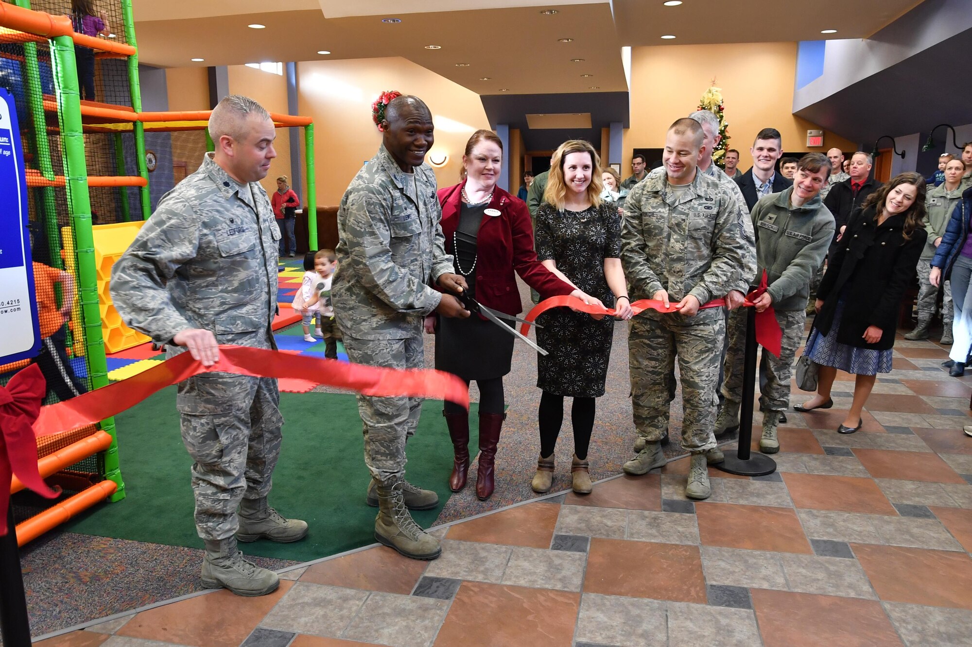 Leaders from the 319th Air Base Wing reopen the Community Activities Center on Grand Forks Air Force Base, N.D., Nov. 21, 2016. The CAC serves as a community commons, which now includes an indoor play center, game area and auditorium. (U.S. Air Force photo by Airman 1st Class Elijaih Tiggs)
