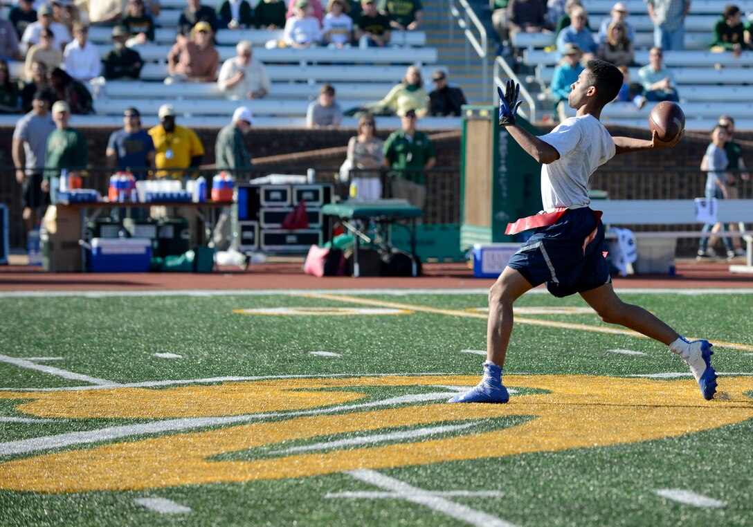 U.S. Air Force Senior Airman Courtland Banks, 1st Aircraft Maintenance Squadron maintenance supply technician, passes the football for a touchdown at the College of William & Mary military appreciation game at Zable Stadium in Williamsburg, Va., Nov. 19, 2016. U.S. Air Force Airmen and U.S. Army Soldiers from Joint Base Langley-Eustis, Va. played for the first place title during the halftime flag football game. (U.S. Air Force photo by Airman 1st Class Kaylee Dubois)