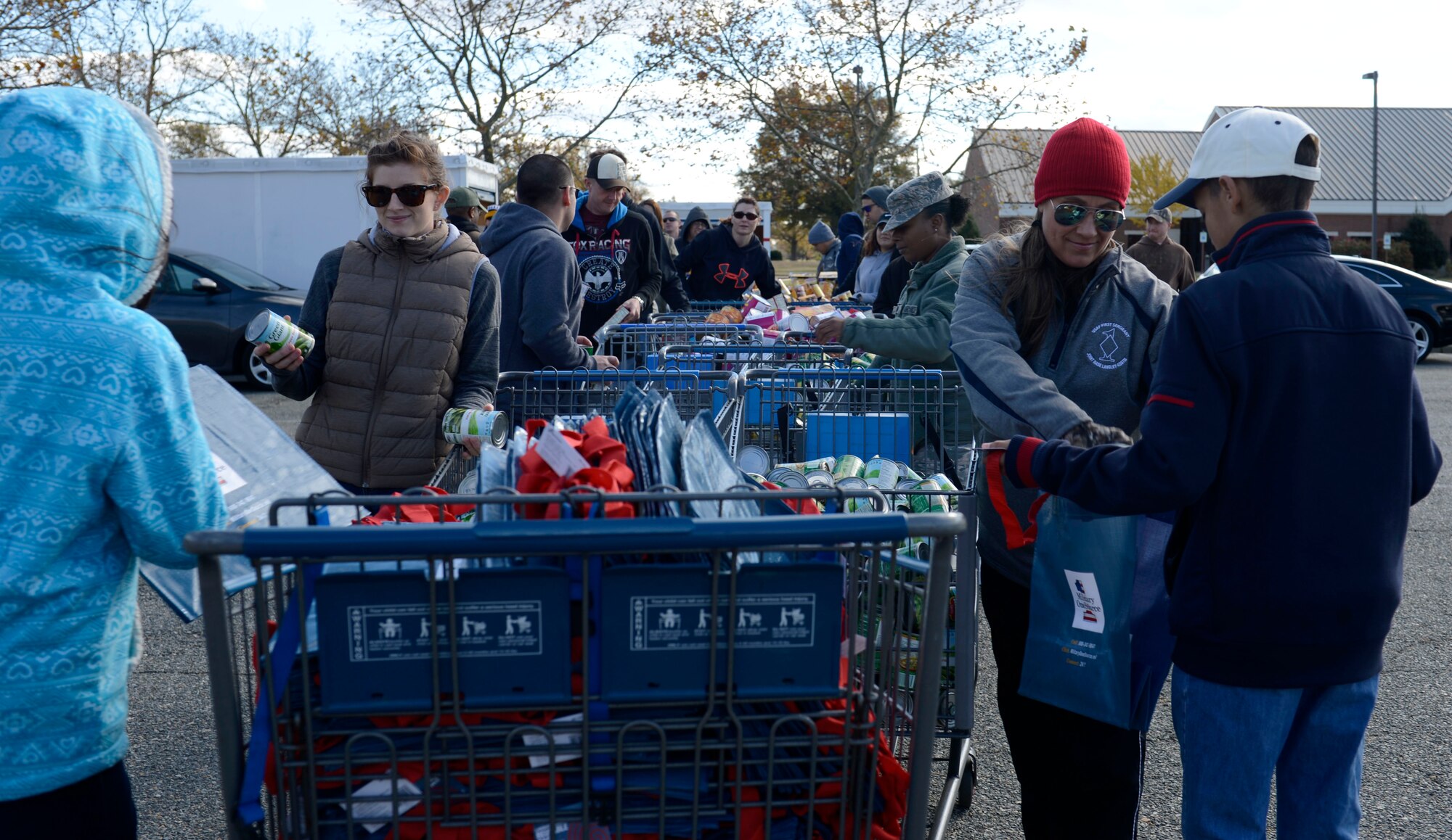 U.S. Air Force Senior Master Sgt. Angela Blue, 633rd Civil Engineer Squadron first sergeant, and 1st Lt. Chelsea Wood, Operation Warmheart volunteer, stuff bags with canned goods for Operation Warmheart at Joint Base Langley-Eustis, Va., Nov. 20, 2016. Operation Warmheart receives a majority of their funds during the holiday season. (U.S. Air Force photo by Airman 1st Class Kaylee Dubois)