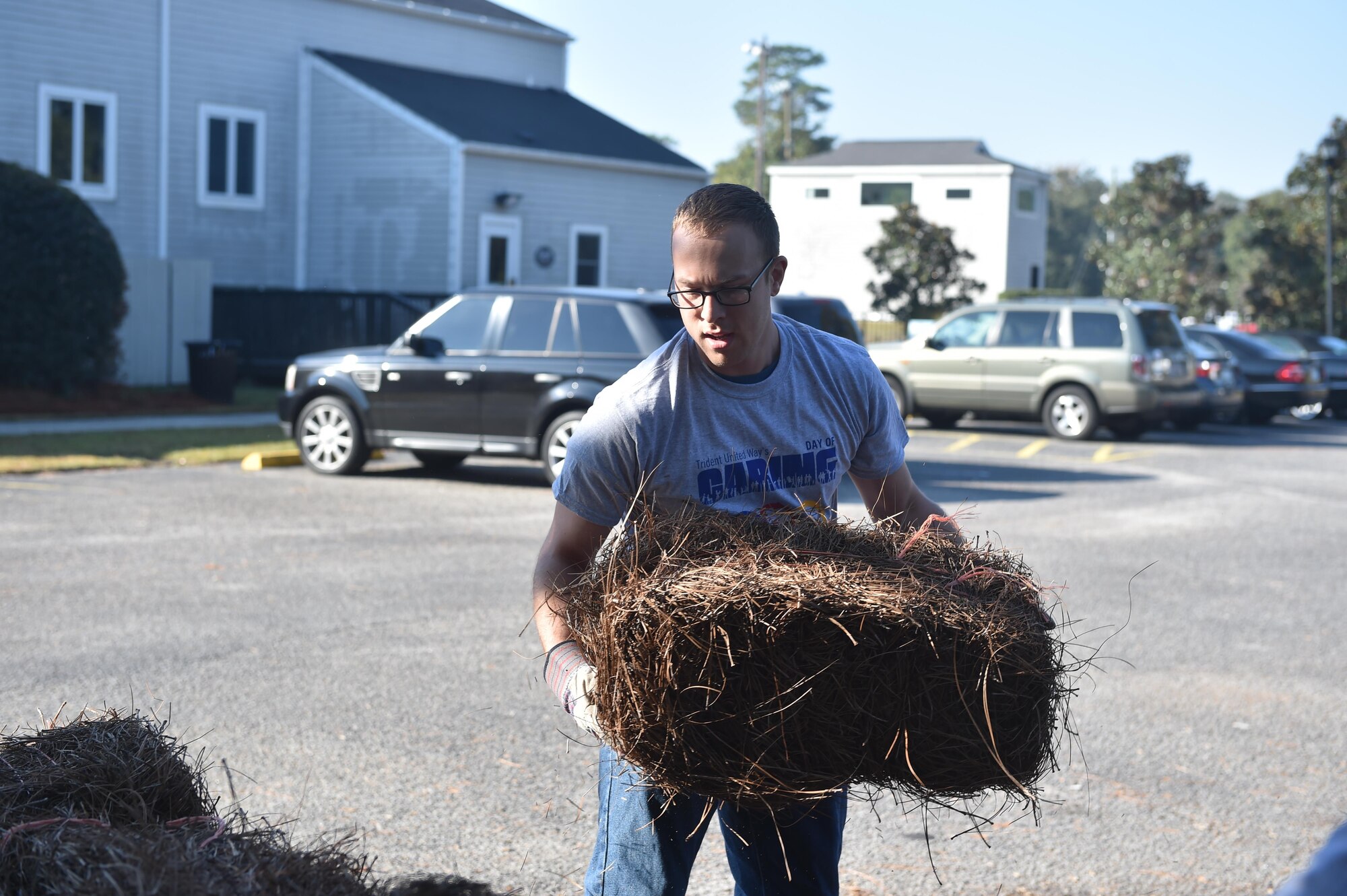 Airman David Dallman, a client systems technician from the 628th Communications Squadron, moves bales of pine straw Nov 18, 2016, at Park Circle Butterfly Garden Charleston, South Carolina, during the Trident United Way’s Day of Caring event. Approximately 200 JB Charleston Airmen and civilians volunteered at 12 different locations in the local community. In total, the annual event brough in more than 5,000 volunteers from the tri-county area as part of Day of Caring 2016. 