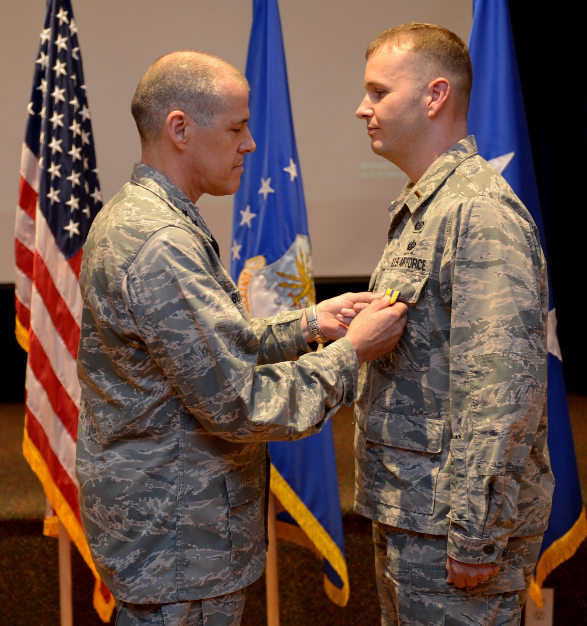 U.S. Air Force Maj. Gen. Thomas Bussiere, 8th Air Force commander, presents the Air Force Commendation Medal to 2d Lt. Matthew Bruce at Barksdale Air Force Base, La., Nov. 17, 2016. (U.S. Air Force photo/Senior Airman Curtis Beach)