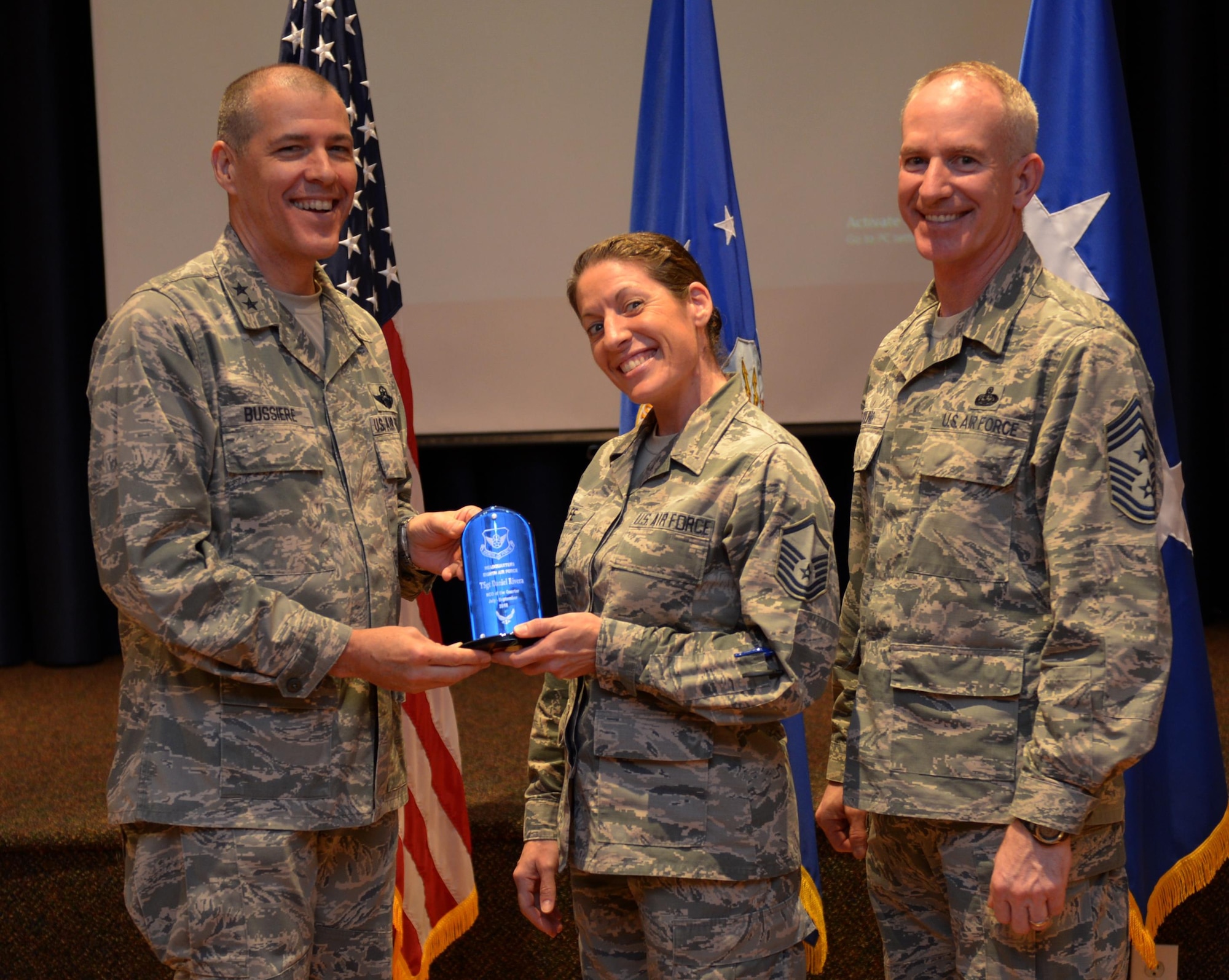 U.S. Air Force Maj. Gen. Thomas Bussiere, 8th Air Force commander, along with CMSgt. Alan Boling, 8th Air Force command chief, recognizes Quarterly Award winner Tech. Sgt. Daniel Rivera at Barksdale Air Force Base, La., Nov. 17, 2016. Accepting on his behalf is Master Sgt. Jennifer Relfe. (U.S. Air Force photo/Senior Airman Curtis Beach)