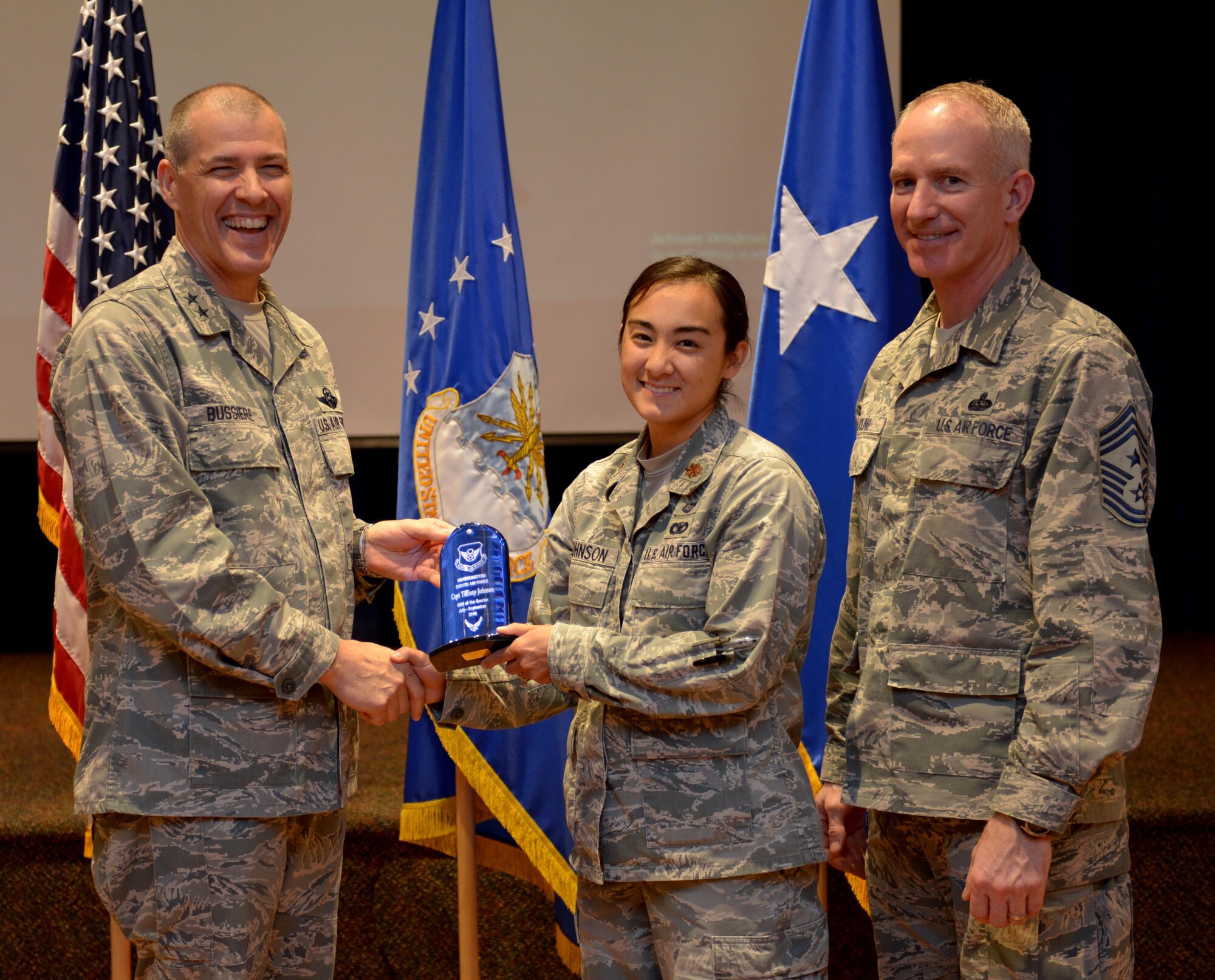 U.S. Air Force Maj. Gen. Thomas Bussiere, 8th Air Force commander, along with CMSgt. Alan Boling, 8th Air Force command chief, recognizes Quarterly Award winner Maj. Tiffany Johnson at Barksdale Air Force Base, La., Nov. 17, 2016. (U.S. Air Force photo/Senior Airman Curtis Beach)