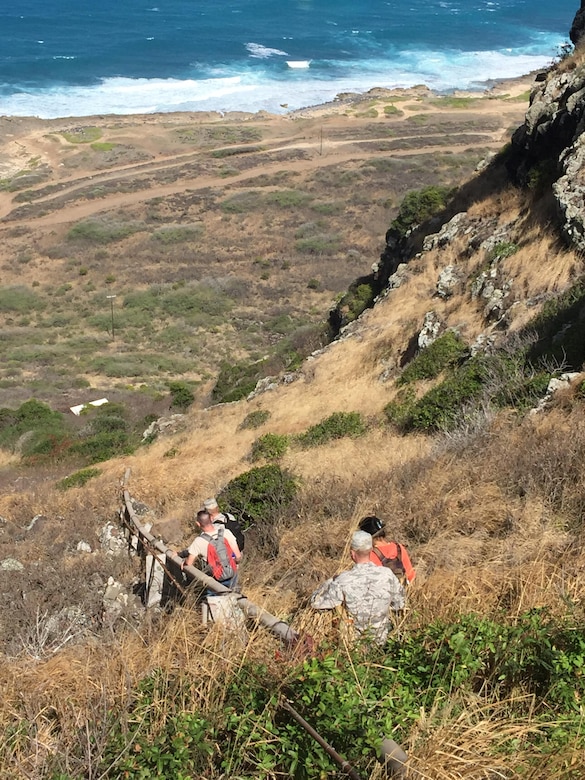 50th Network Operations Group and 50th Mission Support Group members hike down a cliff face in Hawaii to survey the condition of a pipe that supplies water to 21st Space Operations Squadron, Detachment 3 at Ka'ena Point, Hawaii, Wednesday, Nov. 16, 2016.  The 50th Space Wing leaders discussed project and sustainment support with host base leaders during the visit. (Courtesy photo)