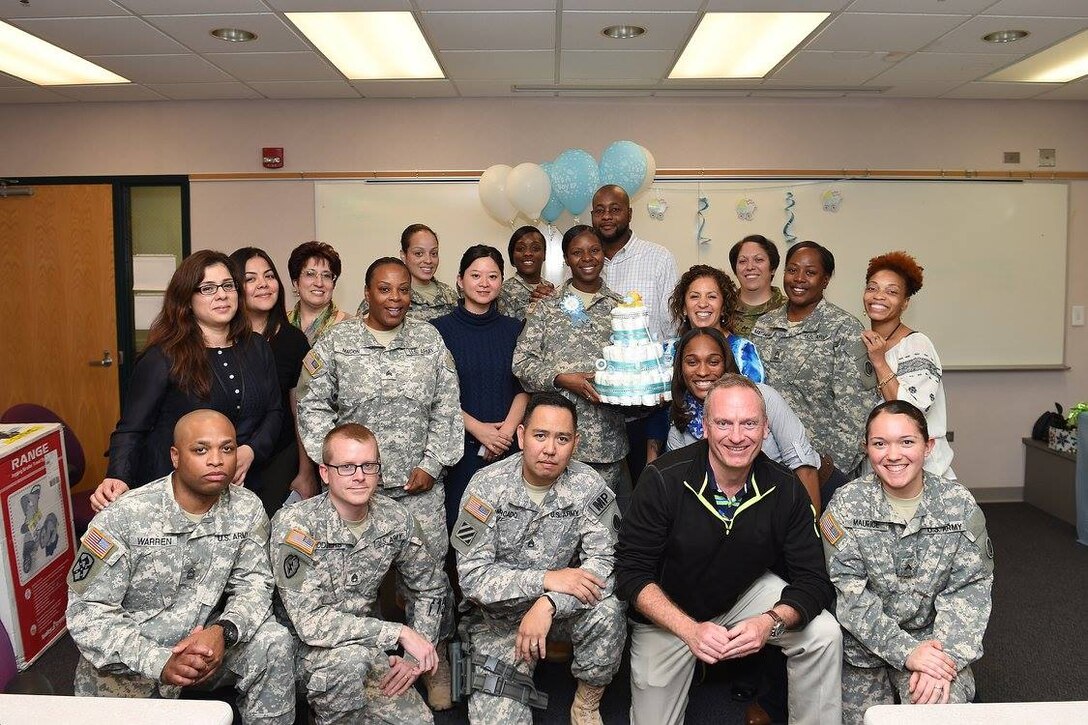 Army Reserve Chief Warrant Officer 3 Monique Perkins, center, 85th Support Command, pauses for a photo with Soldiers and Civilians assigned to the command headquarters, during a baby shower luncheon, Nov. 9, 2016.
(Photo by Anthony L Taylor)