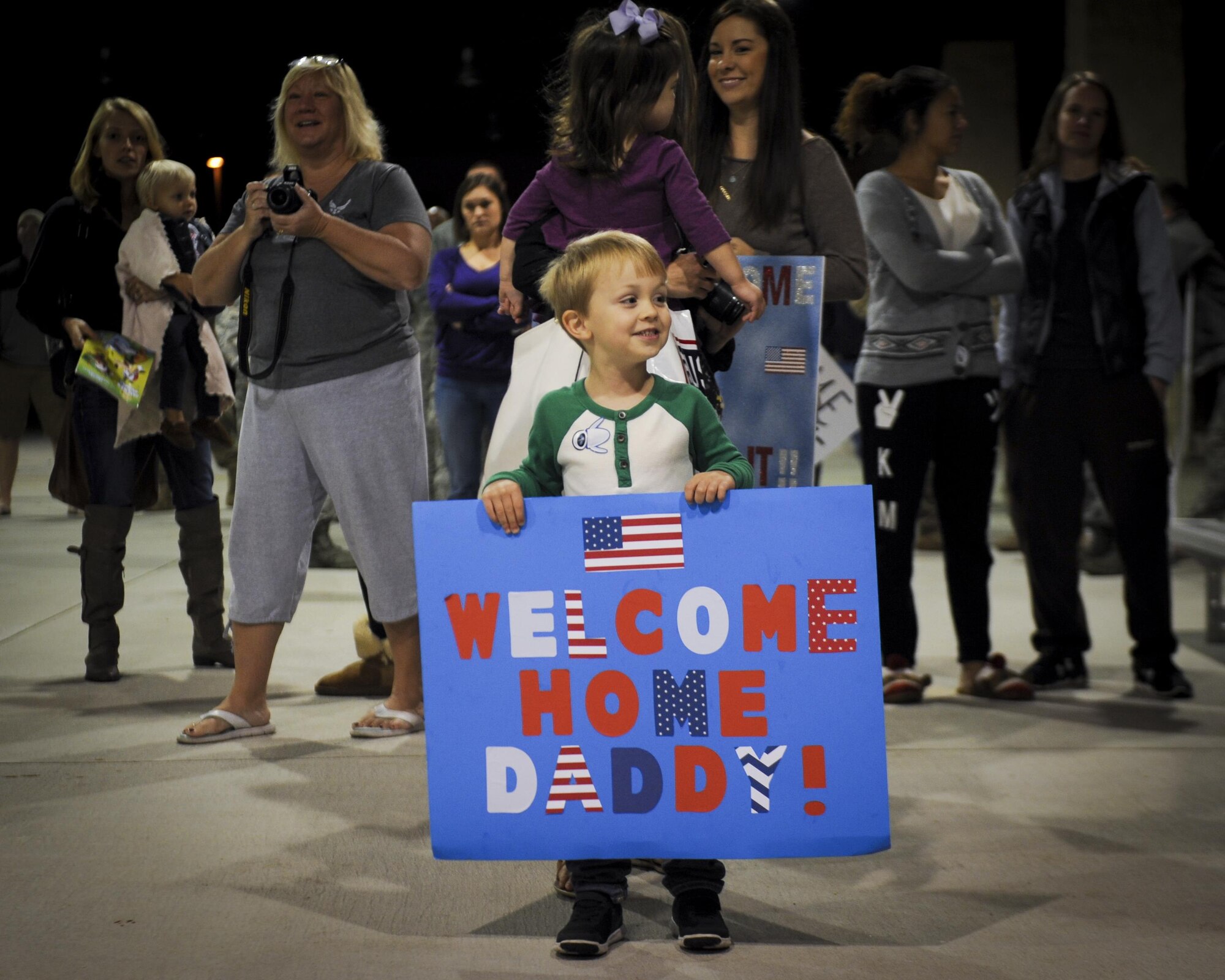 A child holds a poster to celebrate the return of his father after a four-month deployment during Operation Homecoming at Hurlburt Field, Fla., Nov. 10, 2016. Operation Homecoming is a program designed to welcome Air Commandos returning from deployment by family, friends and coworkers. (U.S. Air Force photo by Airman Dennis Spain)