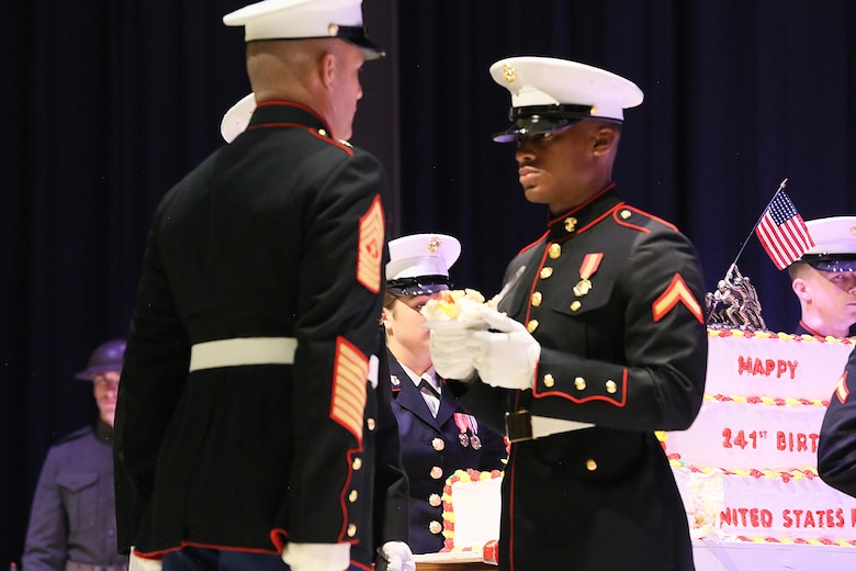 Pfc. Isaiah Living receives a slice of cake from Sgt. Maj. Benjamin Pangborn during the annual Historic Uniform Pageant aboard Marine Corps Air Station Cherry Point, N.C., Nov. 4, 2016. The pageant is held annually to honor the Marine Corps’ birthday, and features Marines wearing uniforms from all major conflicts the Marine Corps has fought in. The pageant also included a traditional cake-cutting ceremony, where the first slice of cake is given to the oldest Marine present and passed to the youngest Marine to symbolize the experience and youthful spirit that are hallmarks of the Marine Corps. Living is an administrations specialist with Headquarters and Headquarters Squadron. (U.S. Marine Corps photo by Lance Cpl. Mackenzie Gibson/Released)
