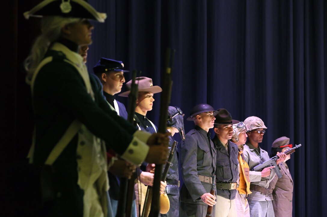 Marines representing the Marine Corps throughout the ages stand on the stage during the annual Historic Uniform Pageant aboard Marine Corps Air Station Cherry Point, N.C., Nov. 4, 2016. The pageant is held to honor the Marine Corps’ birthday and features Marines wearing uniforms from all major conflicts the Marine Corps has fought in. The pageant depicts the Corps’ long illustrious history throughout decades of warfighting. The pageant also included a traditional cake-cutting ceremony representing the passing of traditions from the eldest Marine to the youngest. (U.S. Marine Corps photo by Lance Cpl. Mackenzie Gibson/Released)