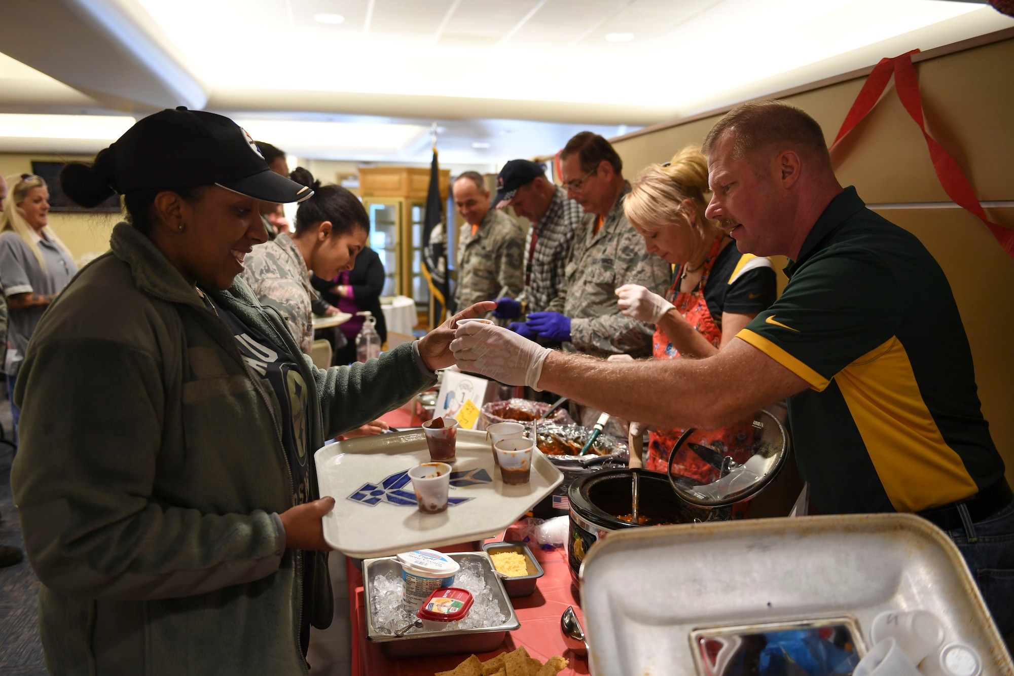 Senior Master Sgt. John Szydel, Specialist Flight Chief with the 911th Maintenance Group, hands cups of his homemade chili to base members at a chili and soup cook-of held at the Pittsburgh International Airport Air Reserve Station, Pa, November 18, 2016. The cook-off was hosted by the Combined Federal Campaign which supports eligible non-profit organizations that provide health and human service benefits throughout the world. (U.S. Air Force photo by Airman 1st Class Beth Kobily)