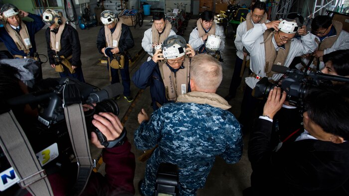 Navy Capt. Ed Thomson, commander of Amphibious Squadron 11; Mr. Norio Tomonaga, the Mayor of Sasebo City, Japan; and the Assemblymen of Defense for Sasebo City put on flight equipment before boarding a MV-22B Osprey tiltrotor aircraft at Sasebo, Nagasaki, Japan, Nov. 18, 2016. The aircraft flew from the island of Okinawa, conducted simulated humanitarian aid with the Japan Maritime Self-Defense Force at multiple locations and was refueled by JMSDF personnel before returning to Okinawa. 