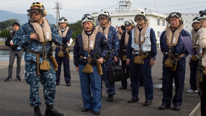Navy Capt. Ed Thomson, commander of Amphibious Squadron 11; Mr. Norio Tomonaga, the Mayor of Sasebo City, Japan; and the Assemblymen of Defense for Sasebo City stand-by to board a MV-22B Osprey tiltrotor aircraft at Sasebo, Nagasaki, Japan, Nov. 18, 2016. The aircraft flew from the island of Okinawa, conducted simulated humanitarian aid with the Japan Maritime Self-Defense Force at multiple locations and was refueled by JMSDF personnel before returning to Okinawa. 